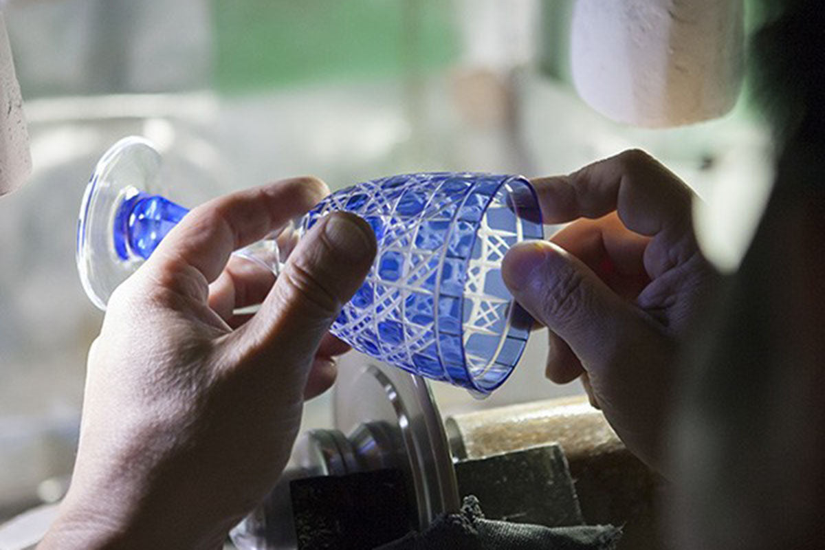 Edo Kiriko rough cutting process, artisan shaping glass with rotating grinding wheel.
