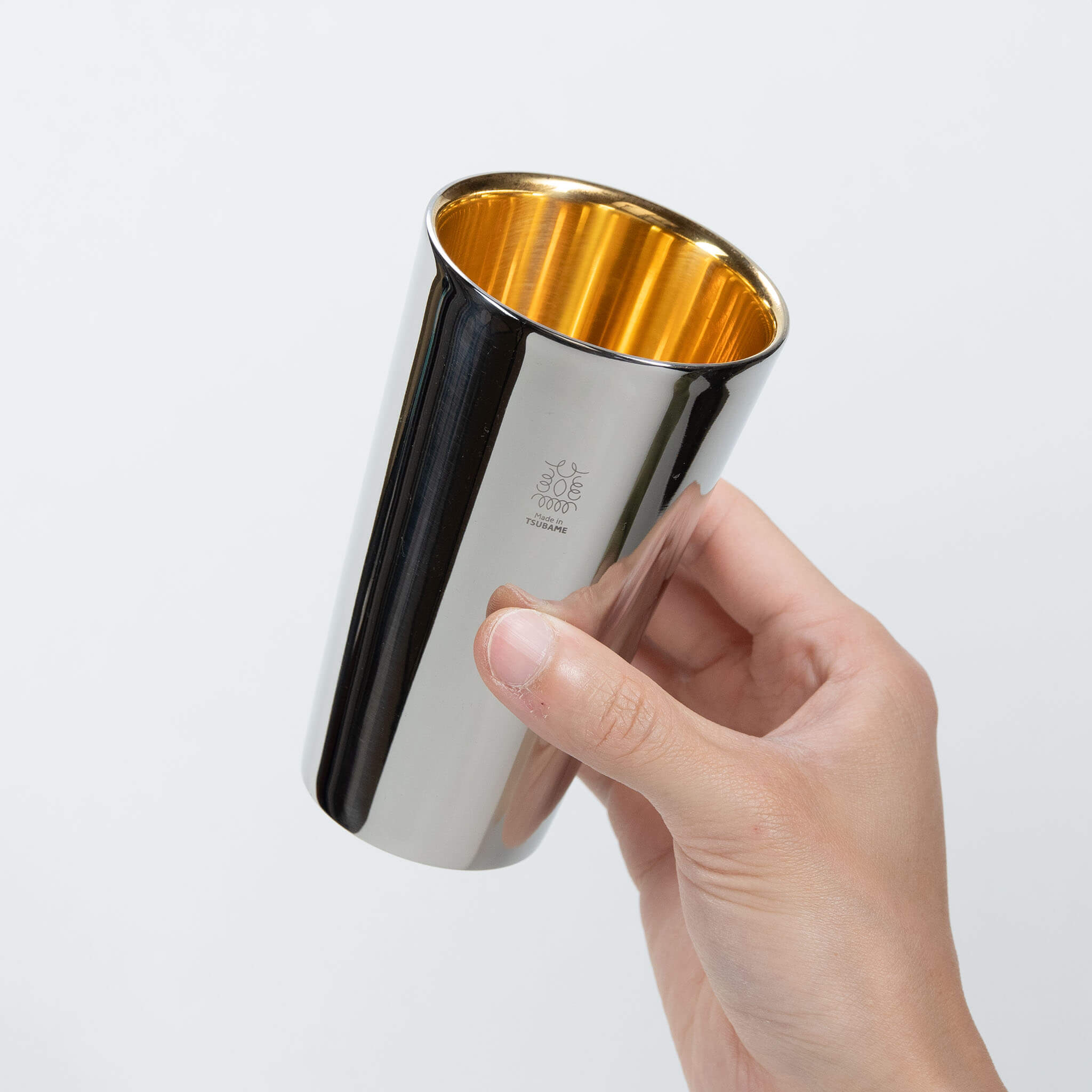 A person holding the premium 300ml Made in Tsubame anti-condensation steel tumbler against a white background.