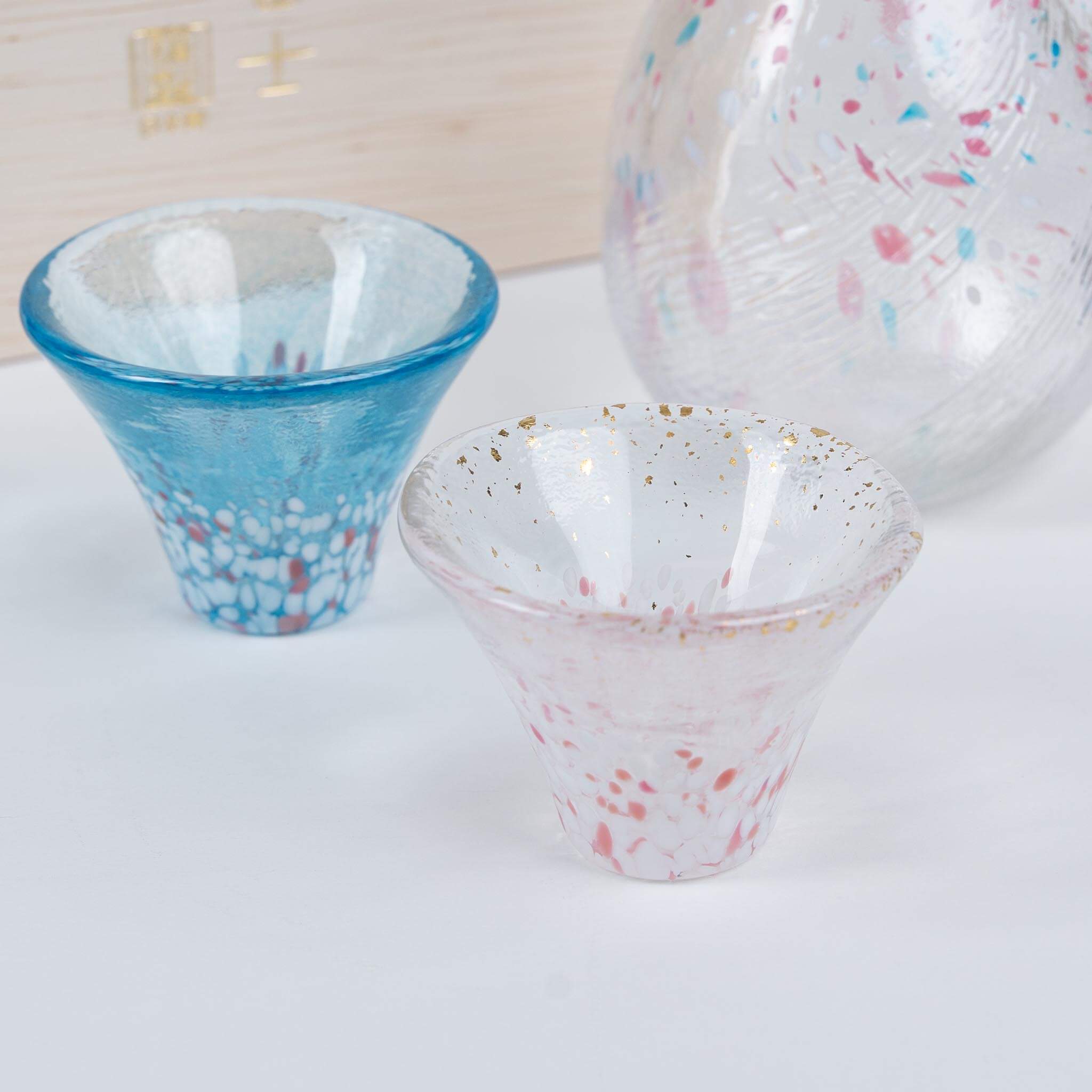 Detail of handmade Japanese sake cup showing unique glass texture inspired by cherry blossoms and Mount Fuji.