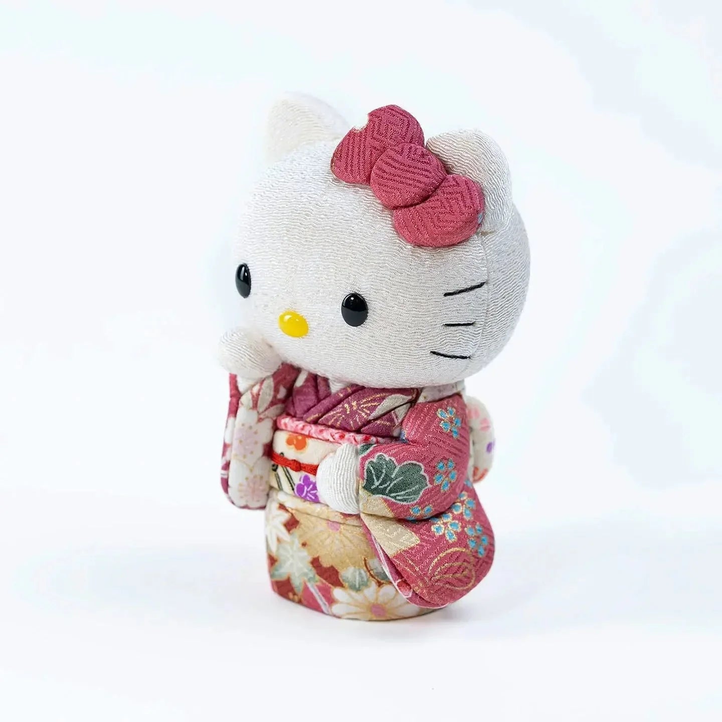 Angled view of the Hello Kitty Maneki Neko (lucky cat) doll on a white background.