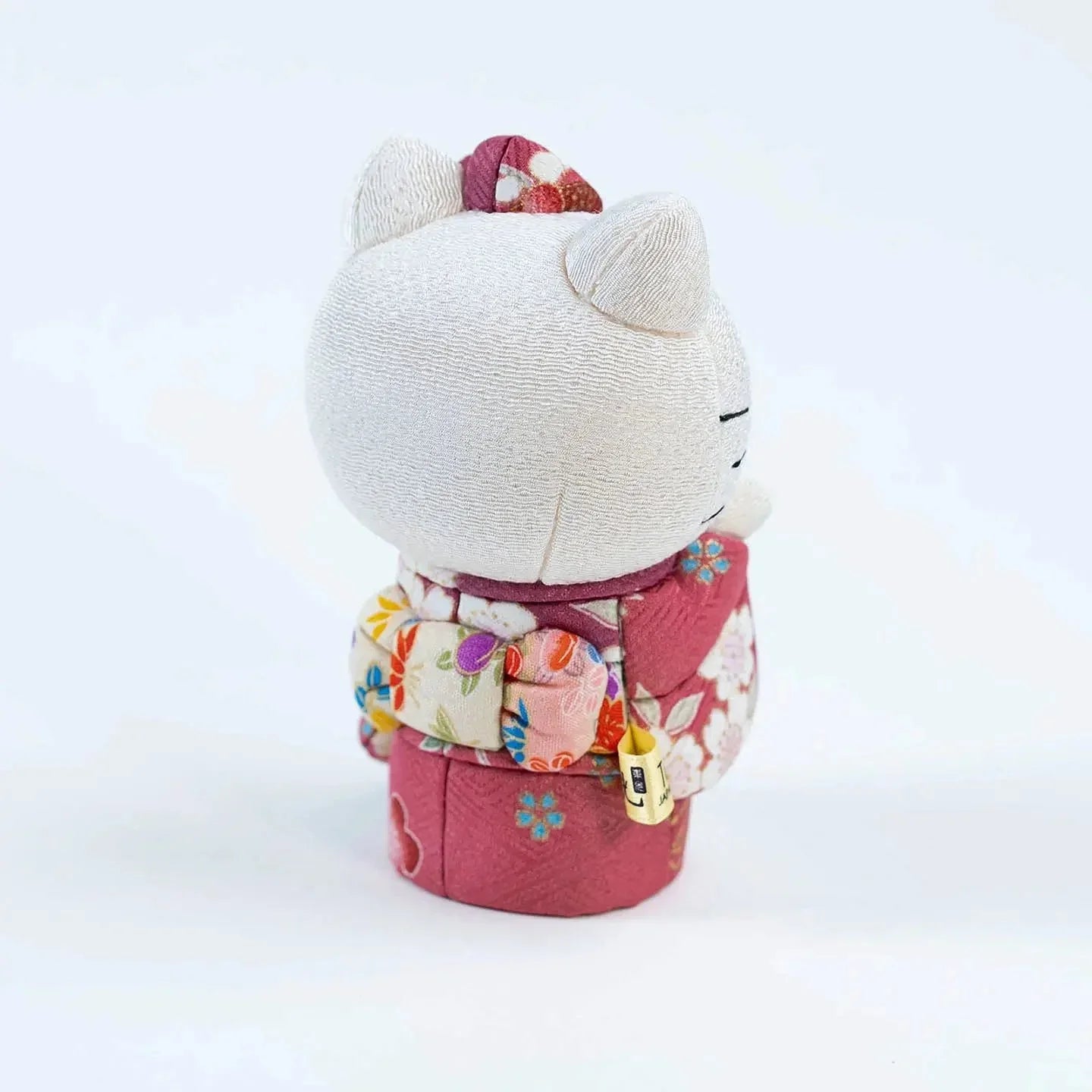 Back view of the Hello Kitty doll, showcasing the craftsmanship of the pink kimono's obi sash.