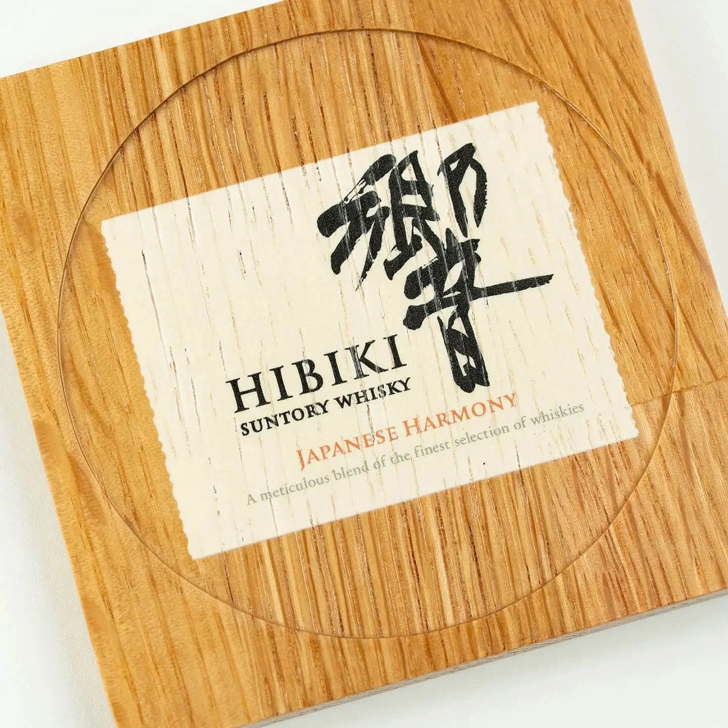 The square Hibiki cask oak coaster, featuring the classic 'Japanese Harmony' whisky label design.