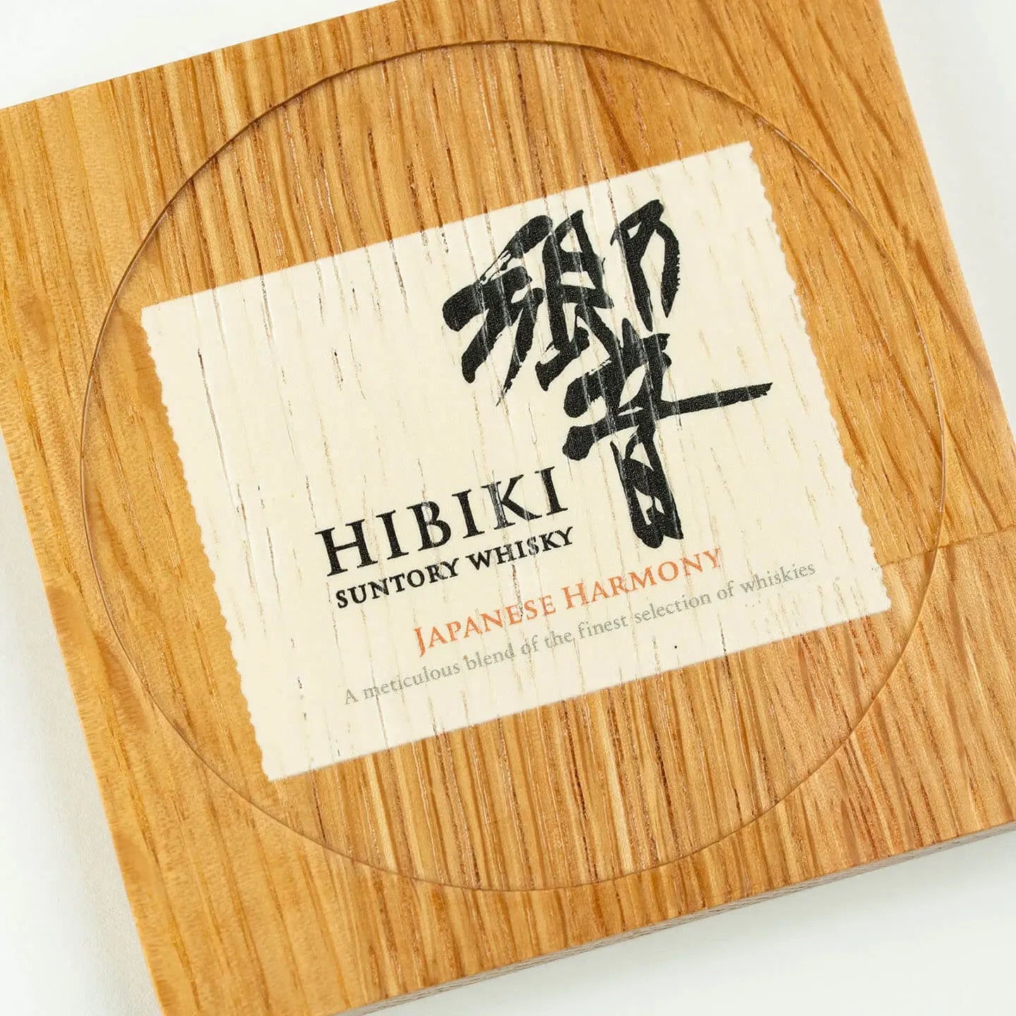 The square Hibiki cask oak coaster, featuring the classic 'Japanese Harmony' whisky label design.