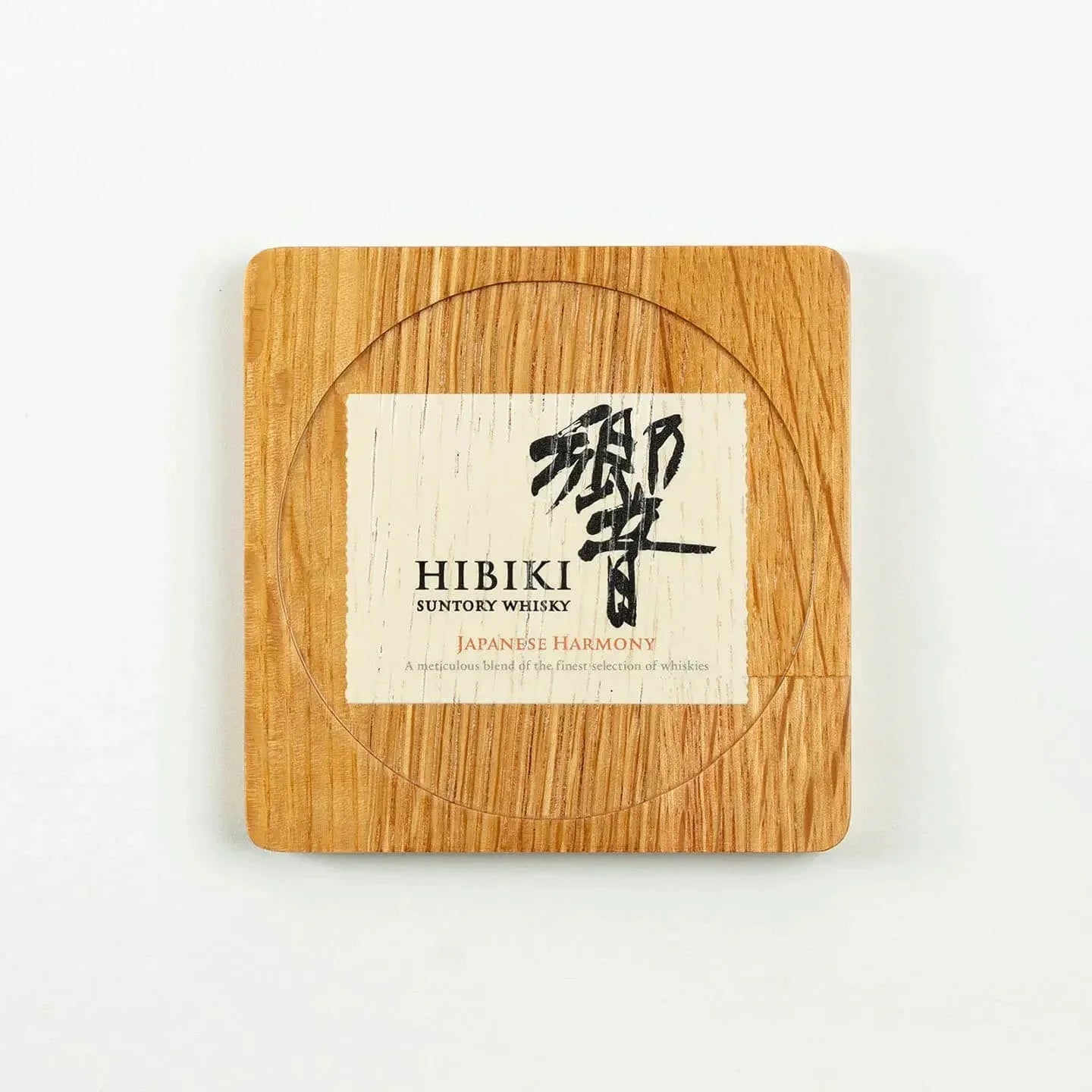 The square Hibiki cask oak coaster, featuring the classic 'Japanese Harmony' whisky label design.
