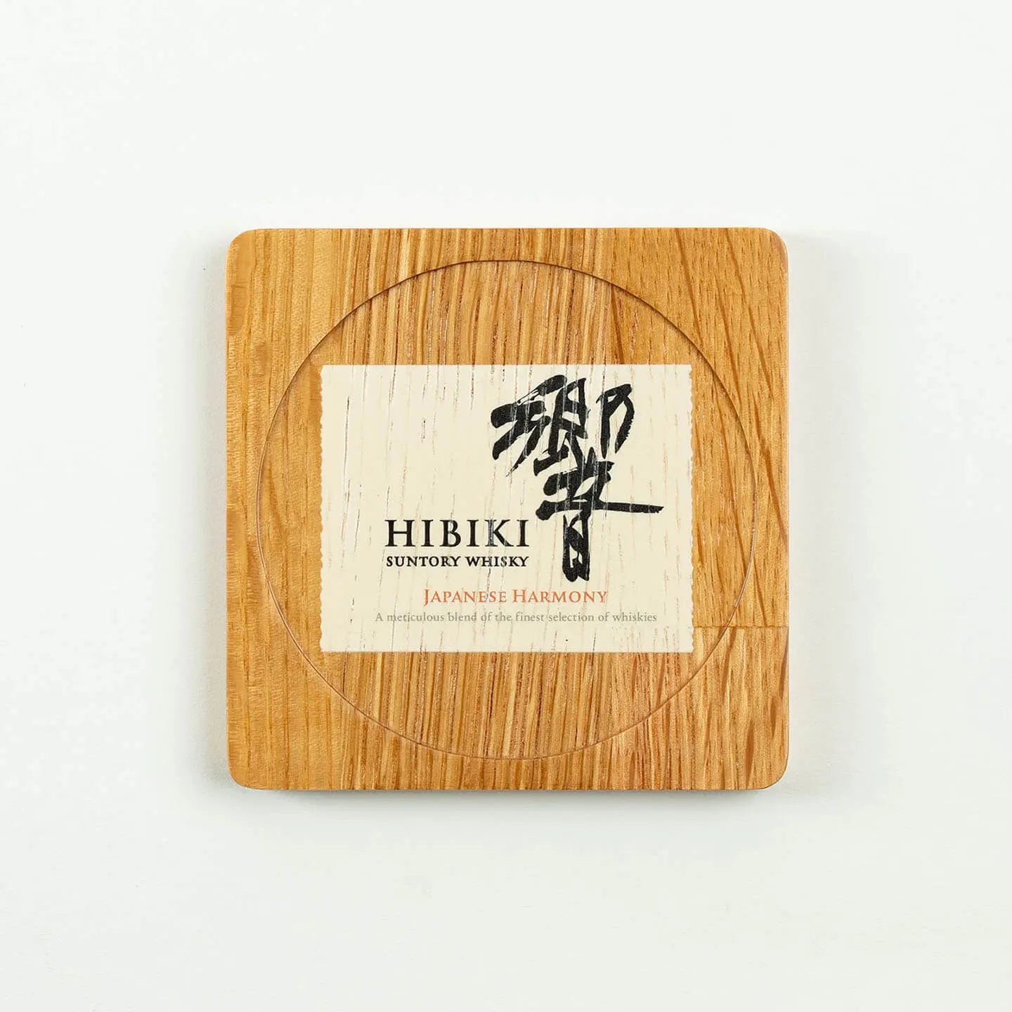 The square Hibiki cask oak coaster, featuring the classic 'Japanese Harmony' whisky label design.