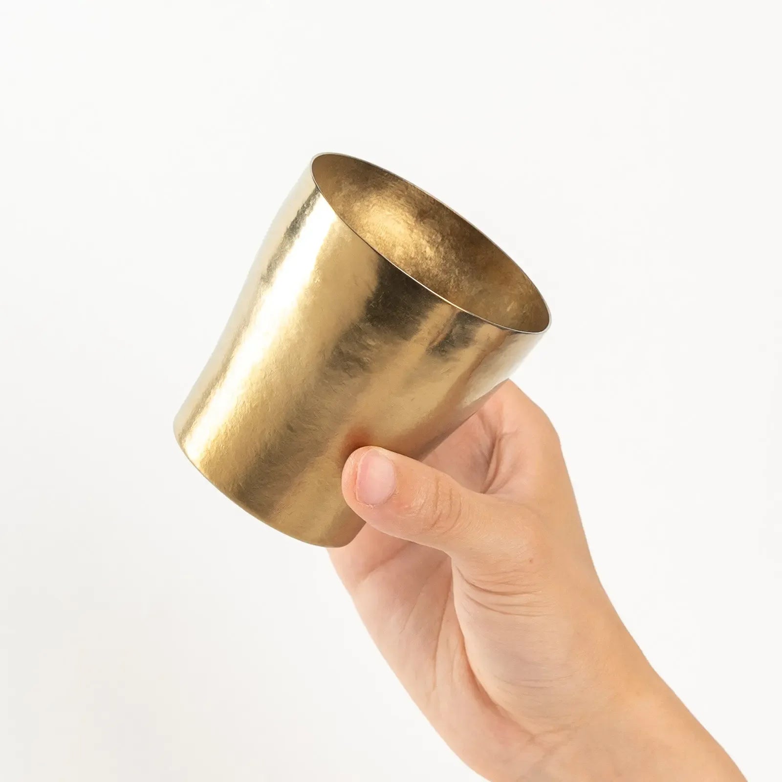 Top view of bronze gold tumbler held in hand showing open mouth