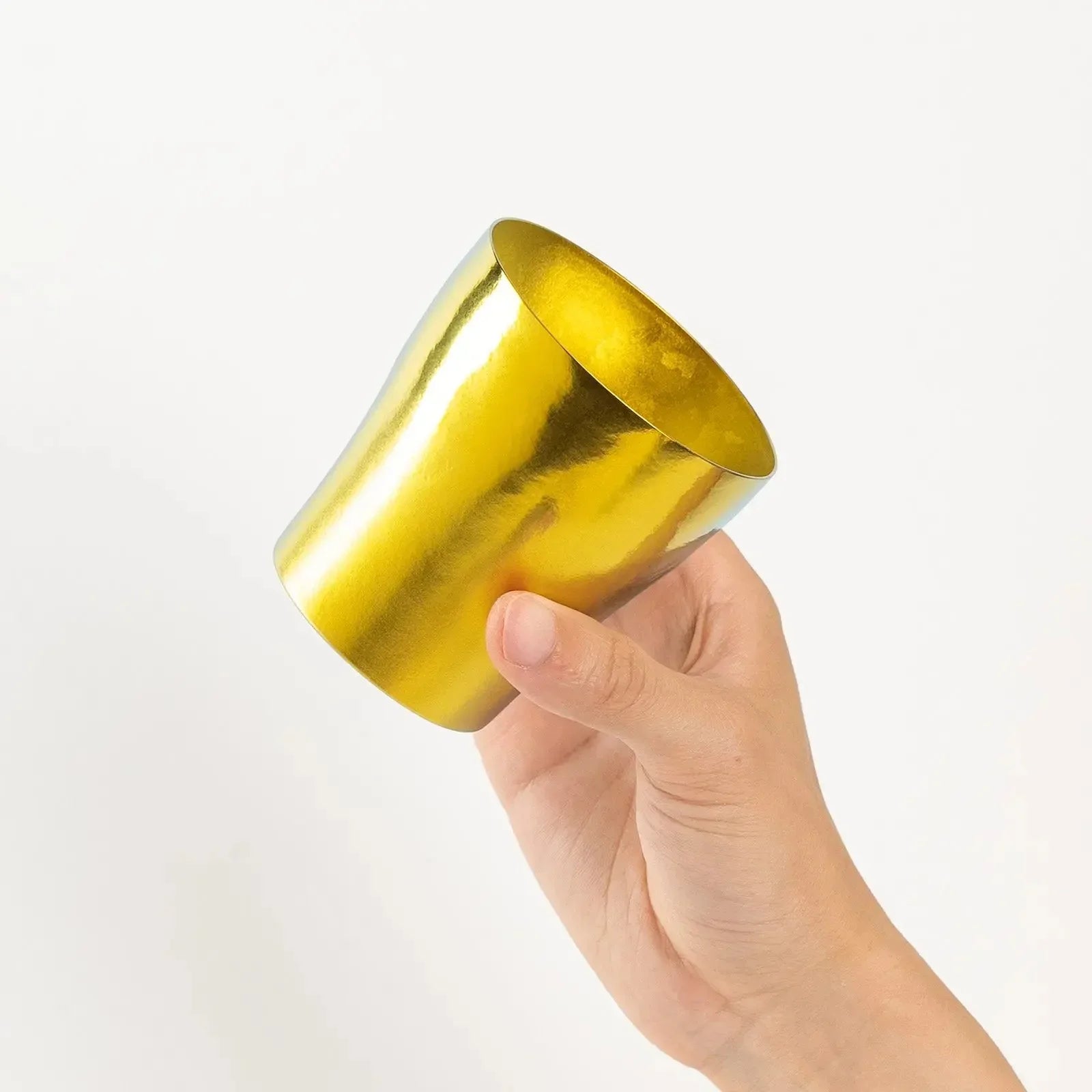 Top-down view of bright gold tumbler held in hand