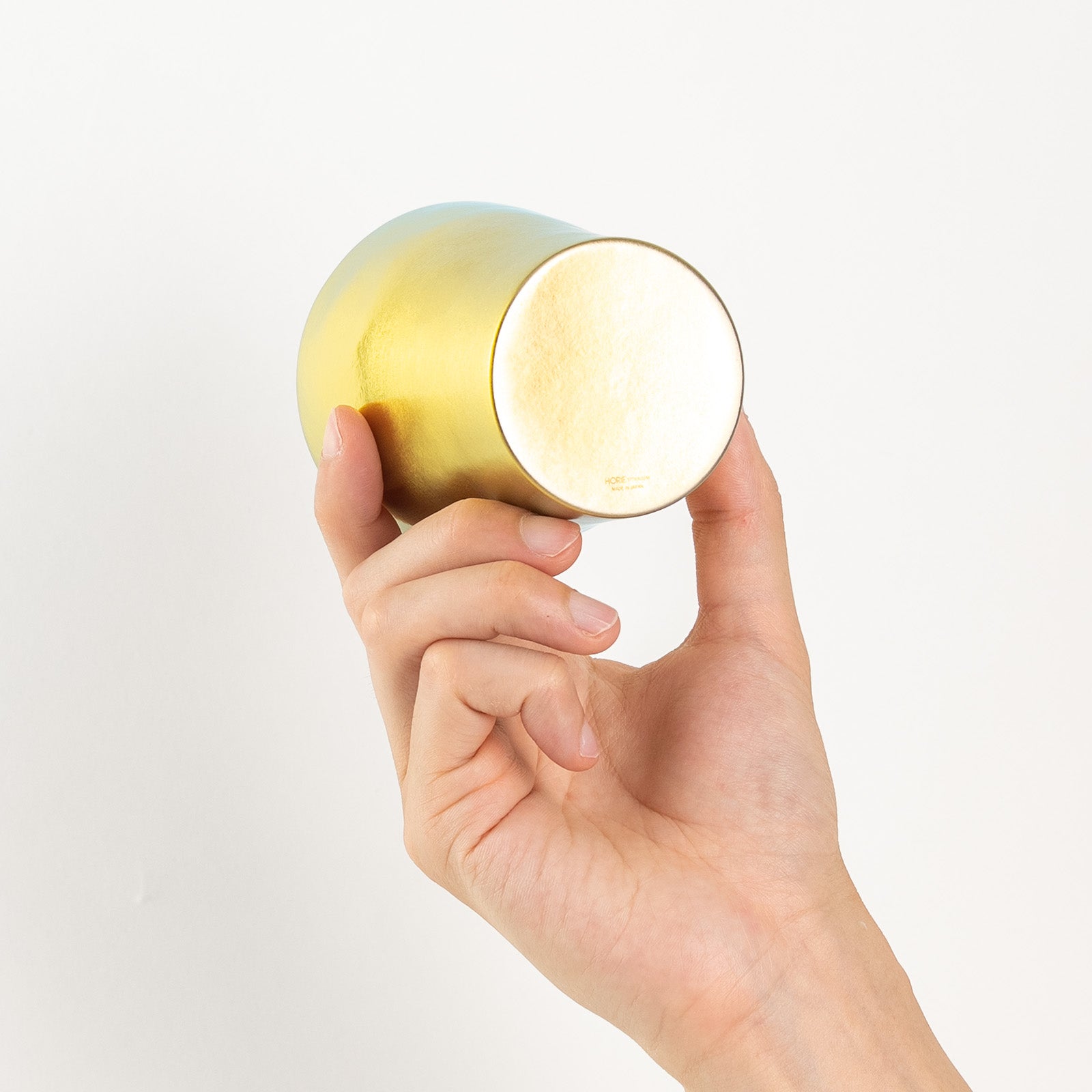 Close-up of HORIE logo on base of bright gold tumbler