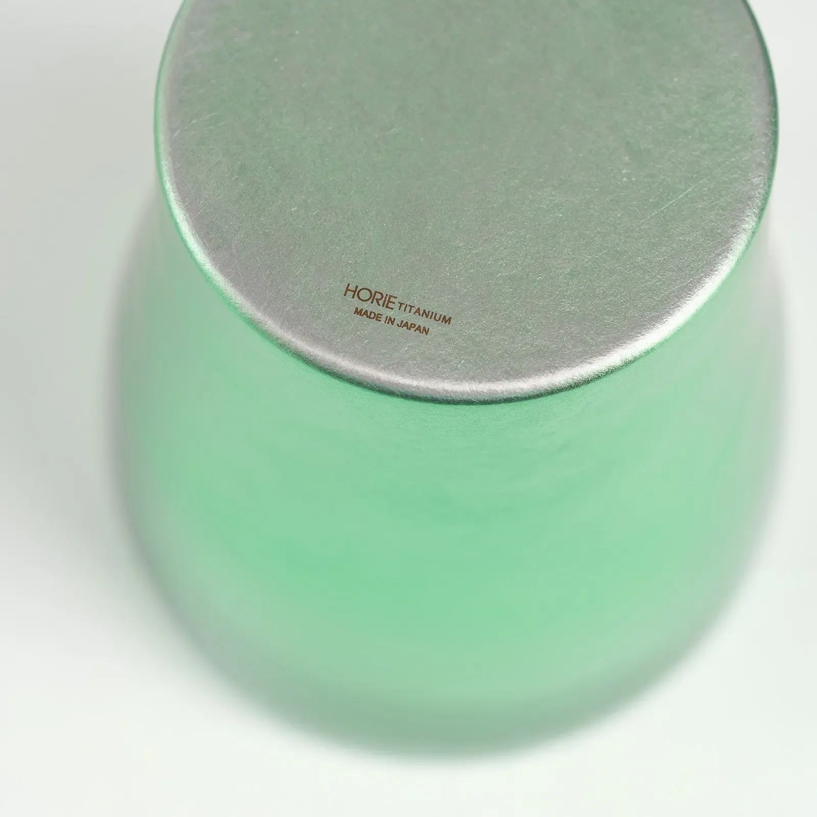 Logo detail on bottom of green titanium tumbler