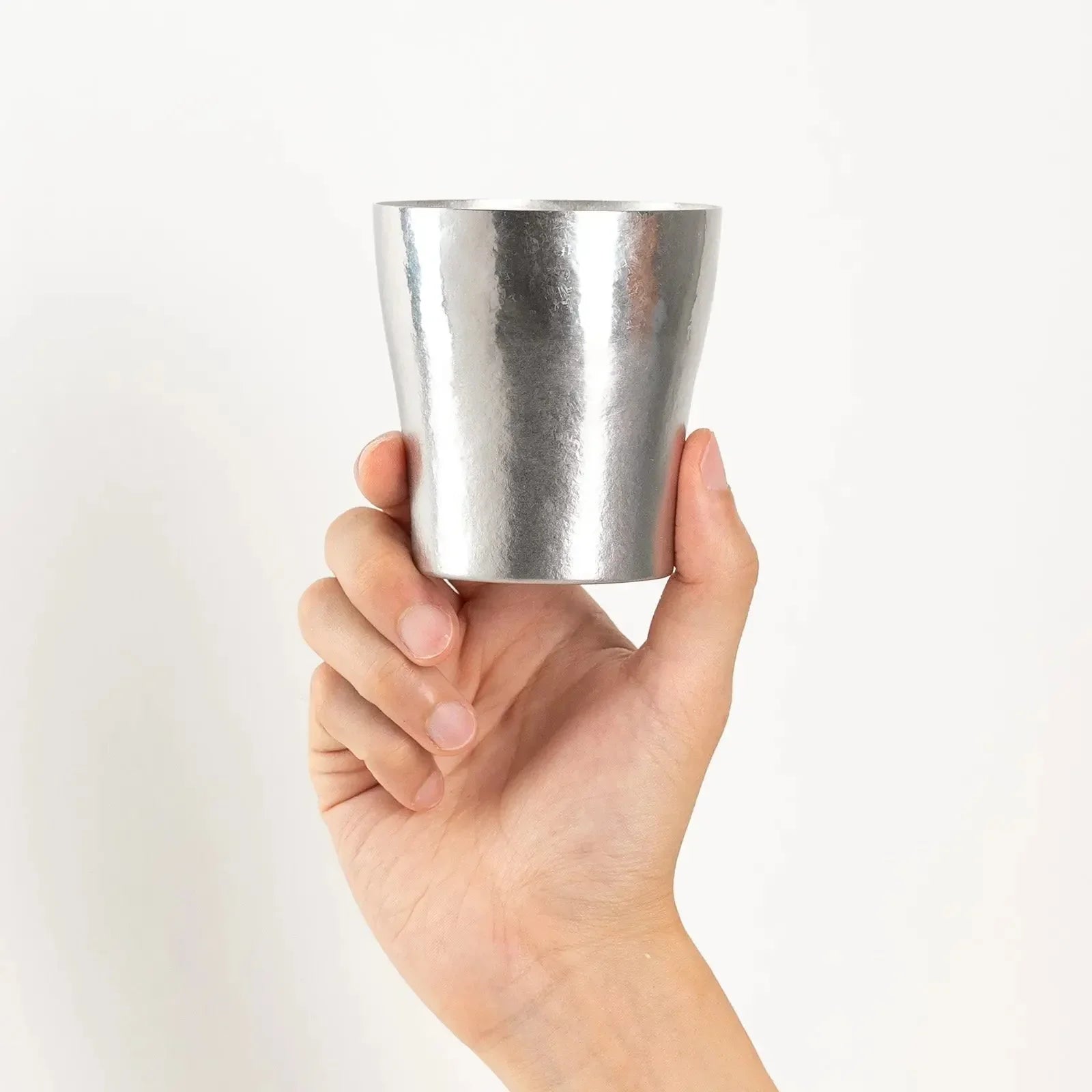 HORIE silver tumbler held in hand from front view