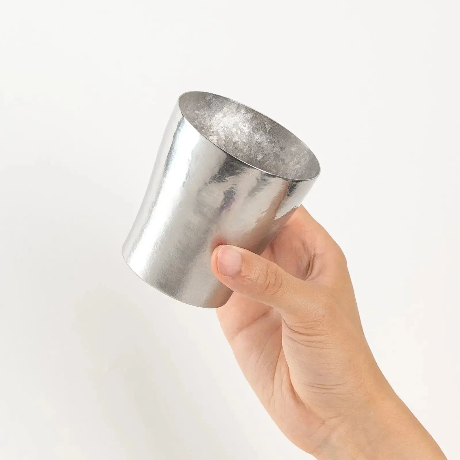 Top view of silver tumbler held in hand showing open mouth