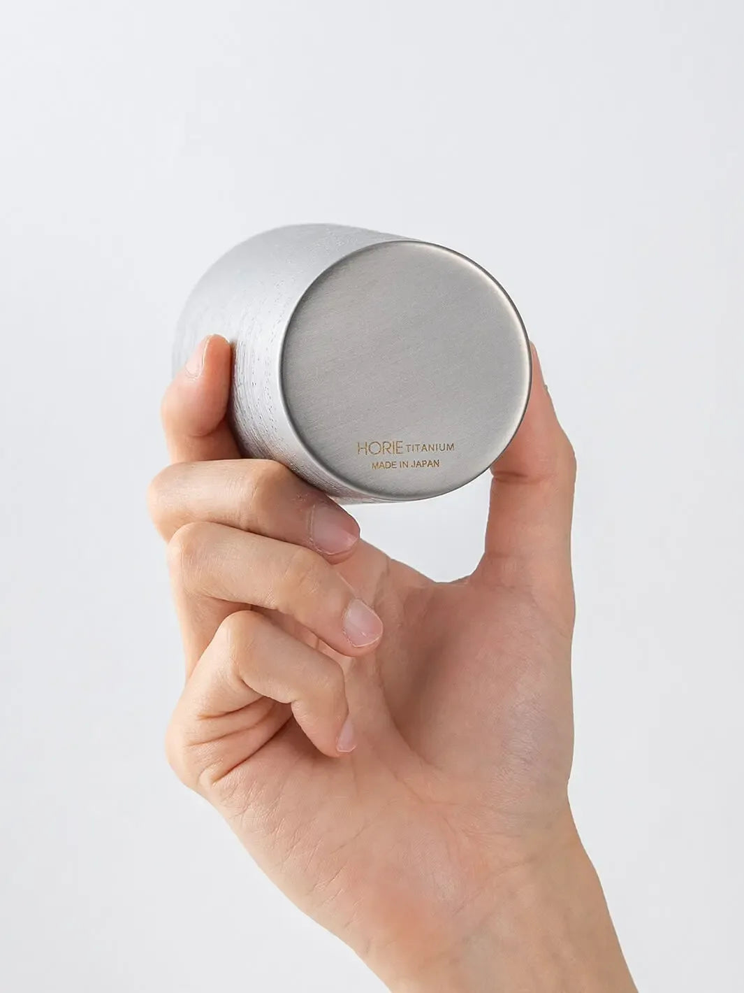 Bottom of HORIE Ryo Silver Mist tumbler (350ml) held in hand, showing engraved base