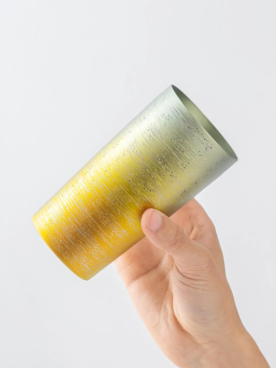 Slightly top-angled view of HORIE Ryo Sunset Gold tumbler (350ml) in hand