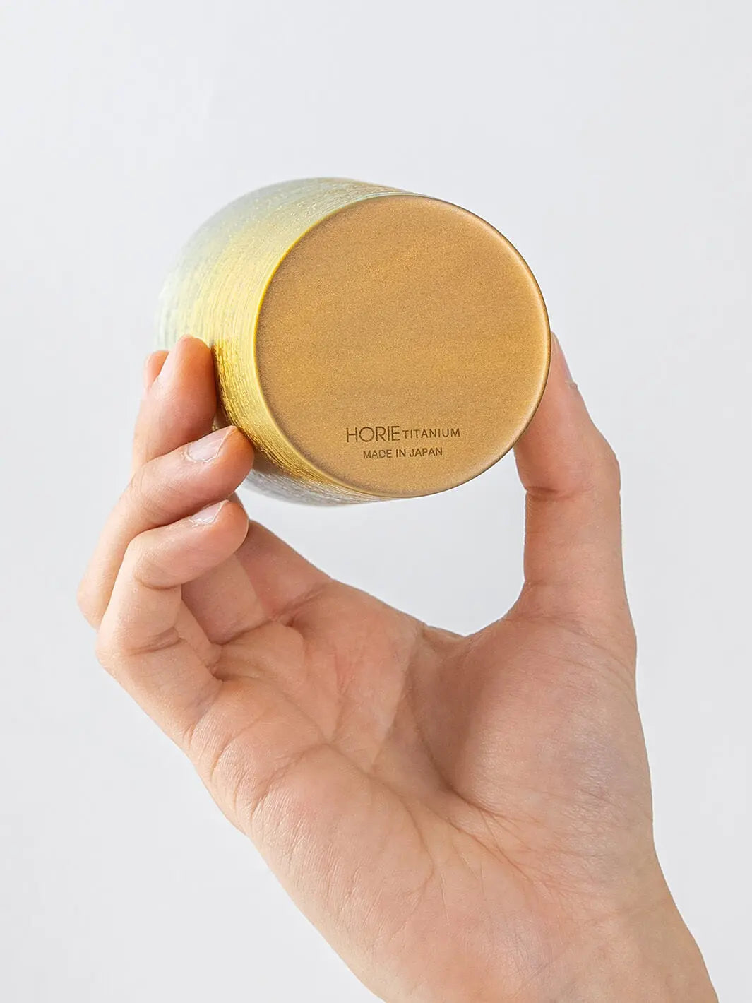 Bottom of HORIE Ryo Sunset Gold tumbler (350ml) held in hand, showing engraved base