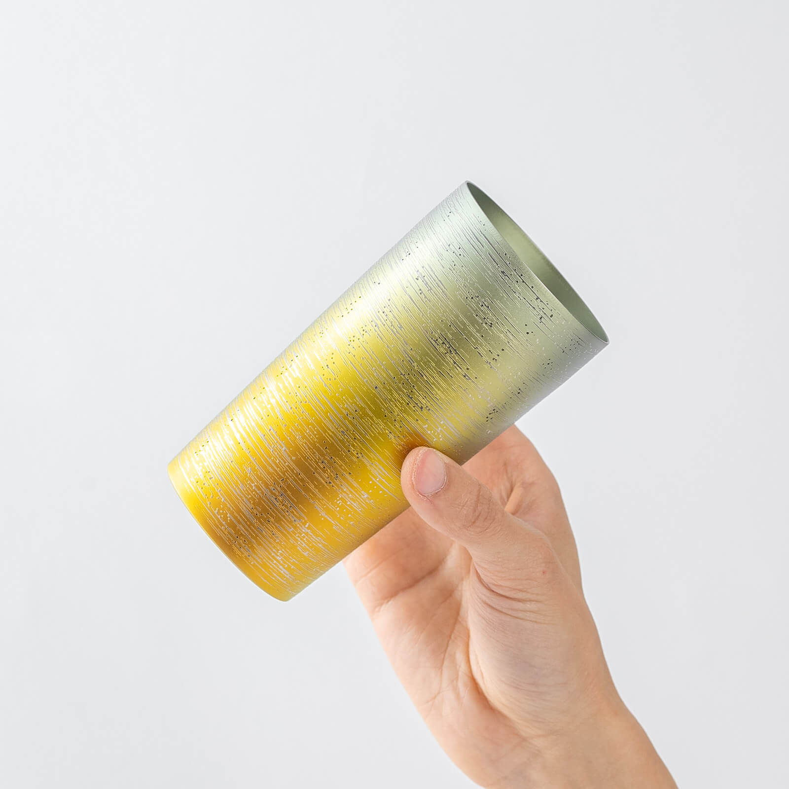 Slightly top-angled view of HORIE Ryo Sunset Gold tumbler (350ml) in hand