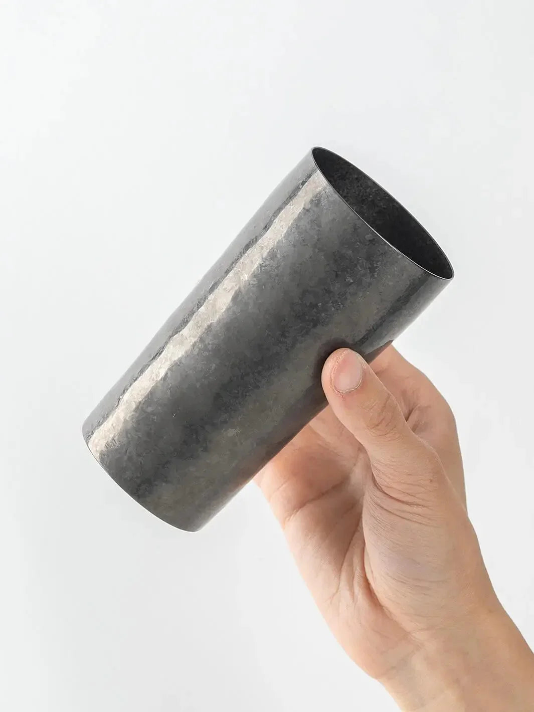 Side view of black HORIE titanium tumbler held in hand