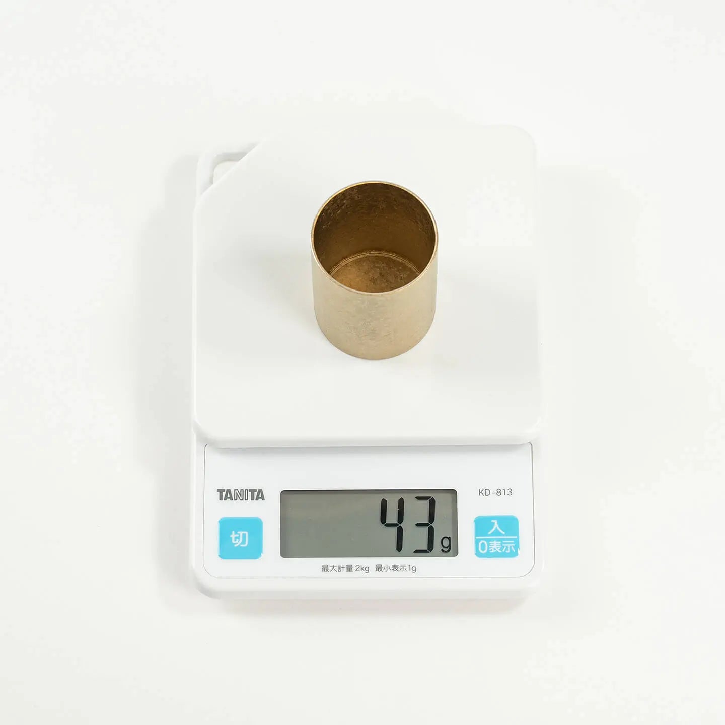 The HORIE Titanium Sake Cup on a digital scale, demonstrating its incredibly light weight of only 43 grams.