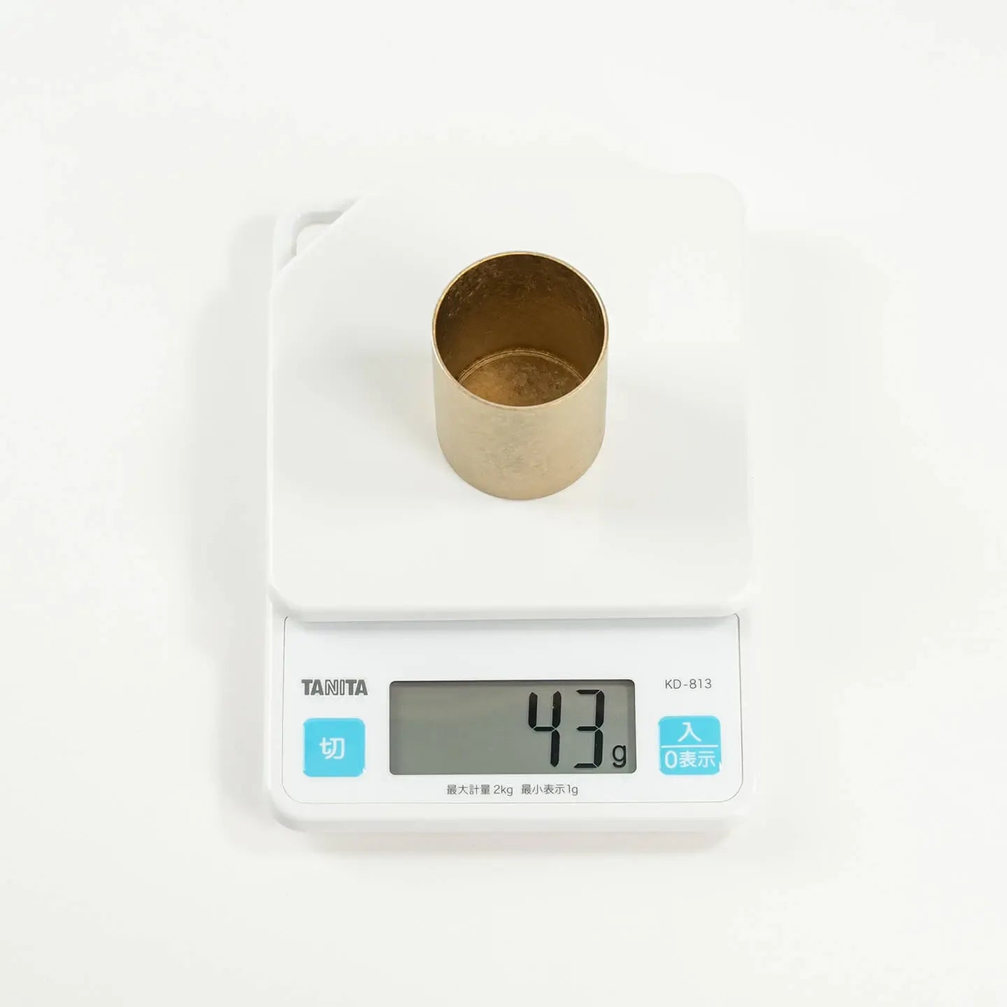 The HORIE Titanium Sake Cup on a digital scale, demonstrating its incredibly light weight of only 43 grams.