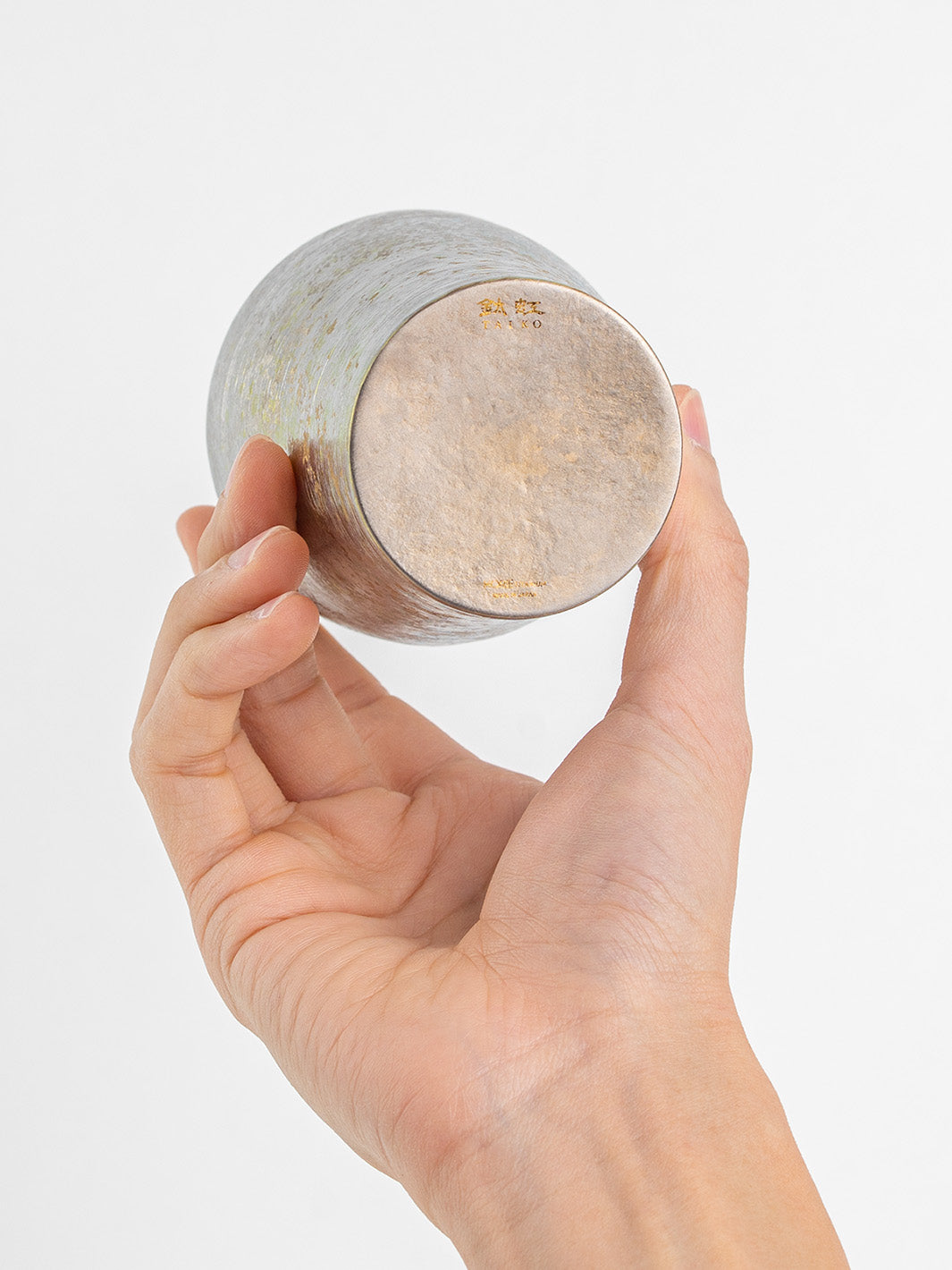 Bottom view of silver tumbler shown in hand