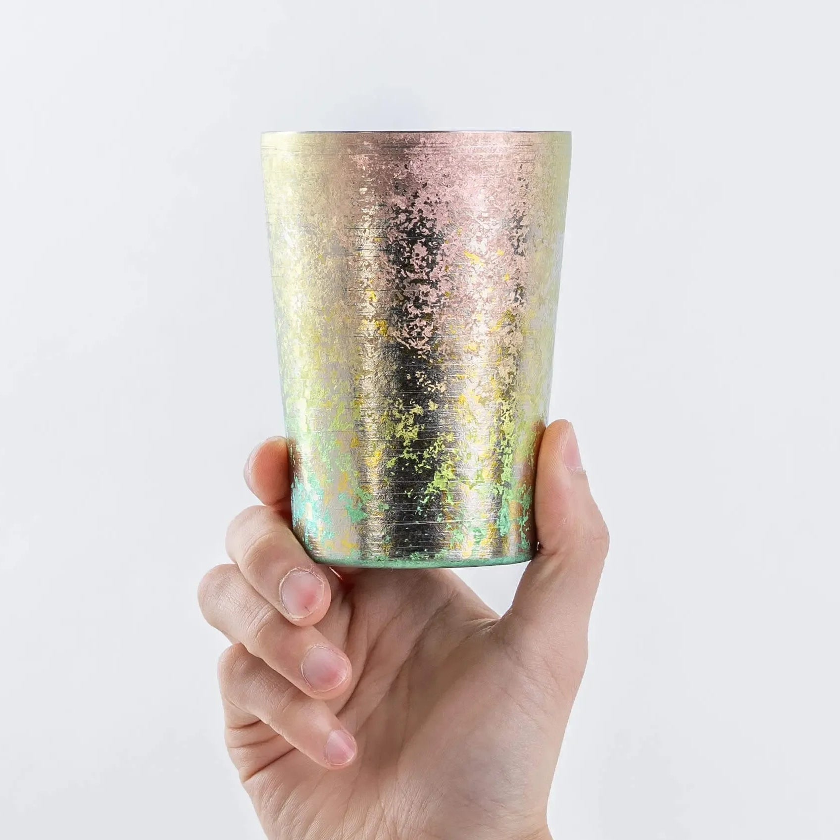 Pink titanium tumbler held upright in hand, 400ml