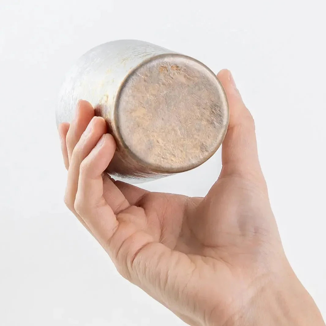 Bottom of silver titanium tumbler shown in hand