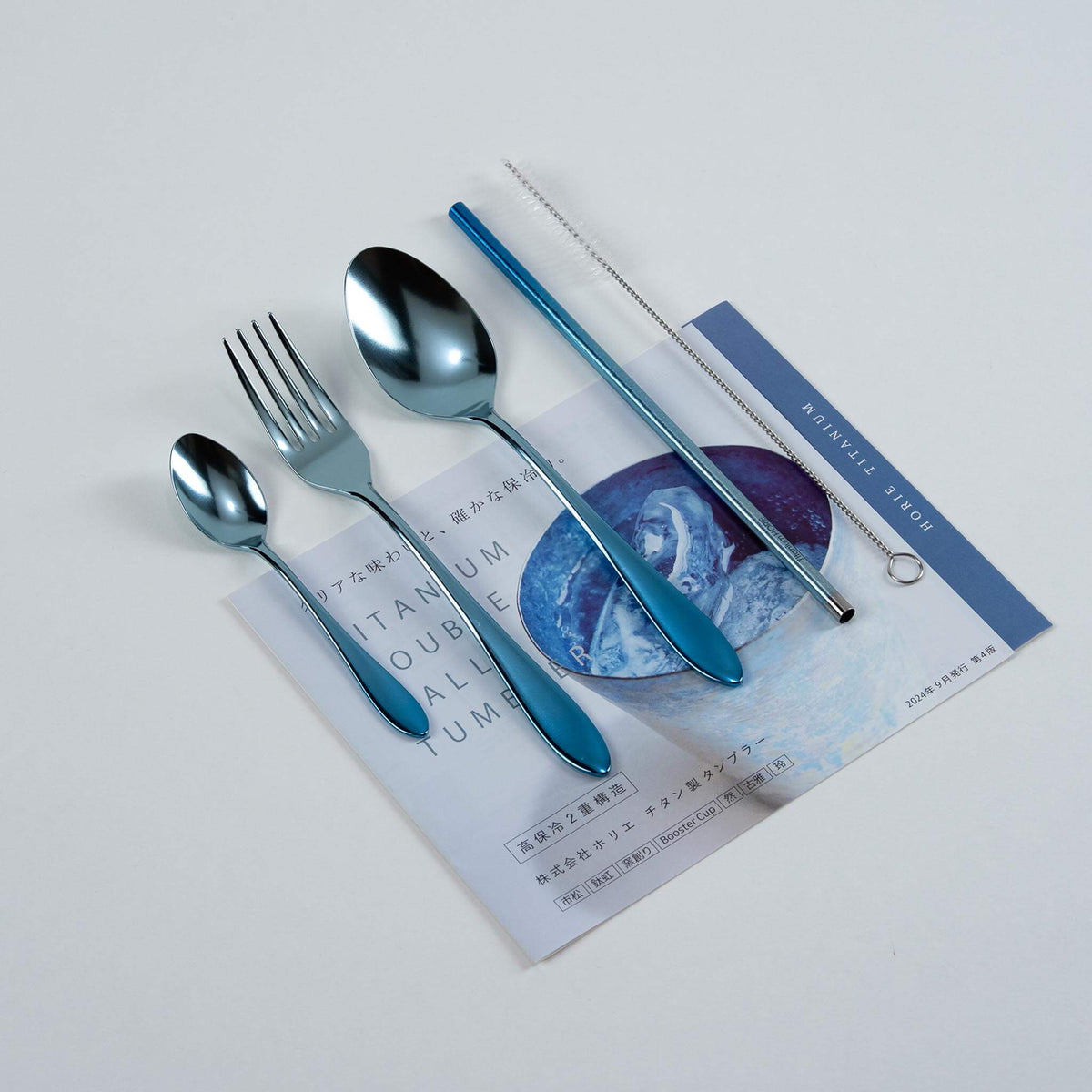 Blue HORIE pure titanium cutlery set arranged on a Japanese magazine