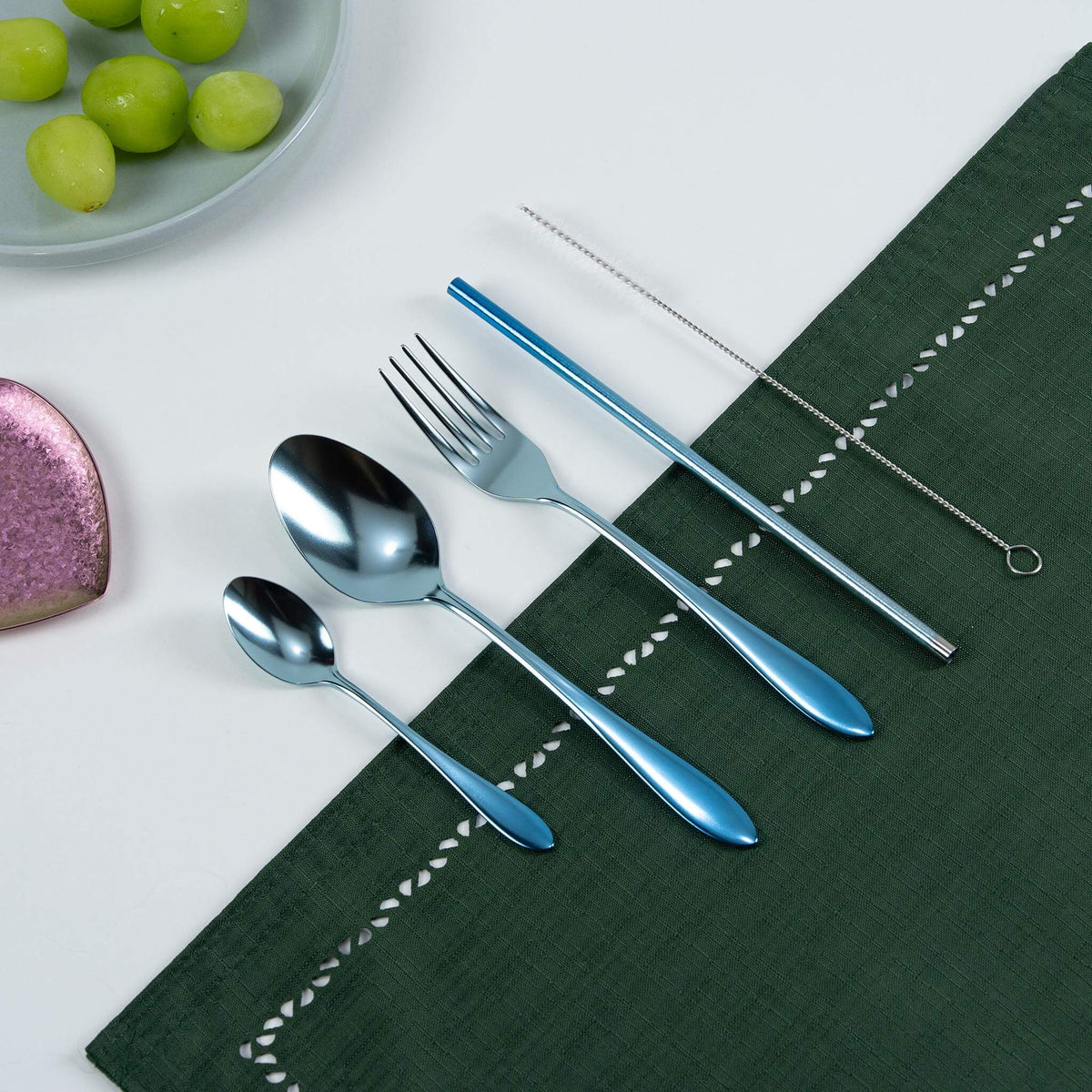 HORIE blue titanium cutlery set arranged on a green tablecloth