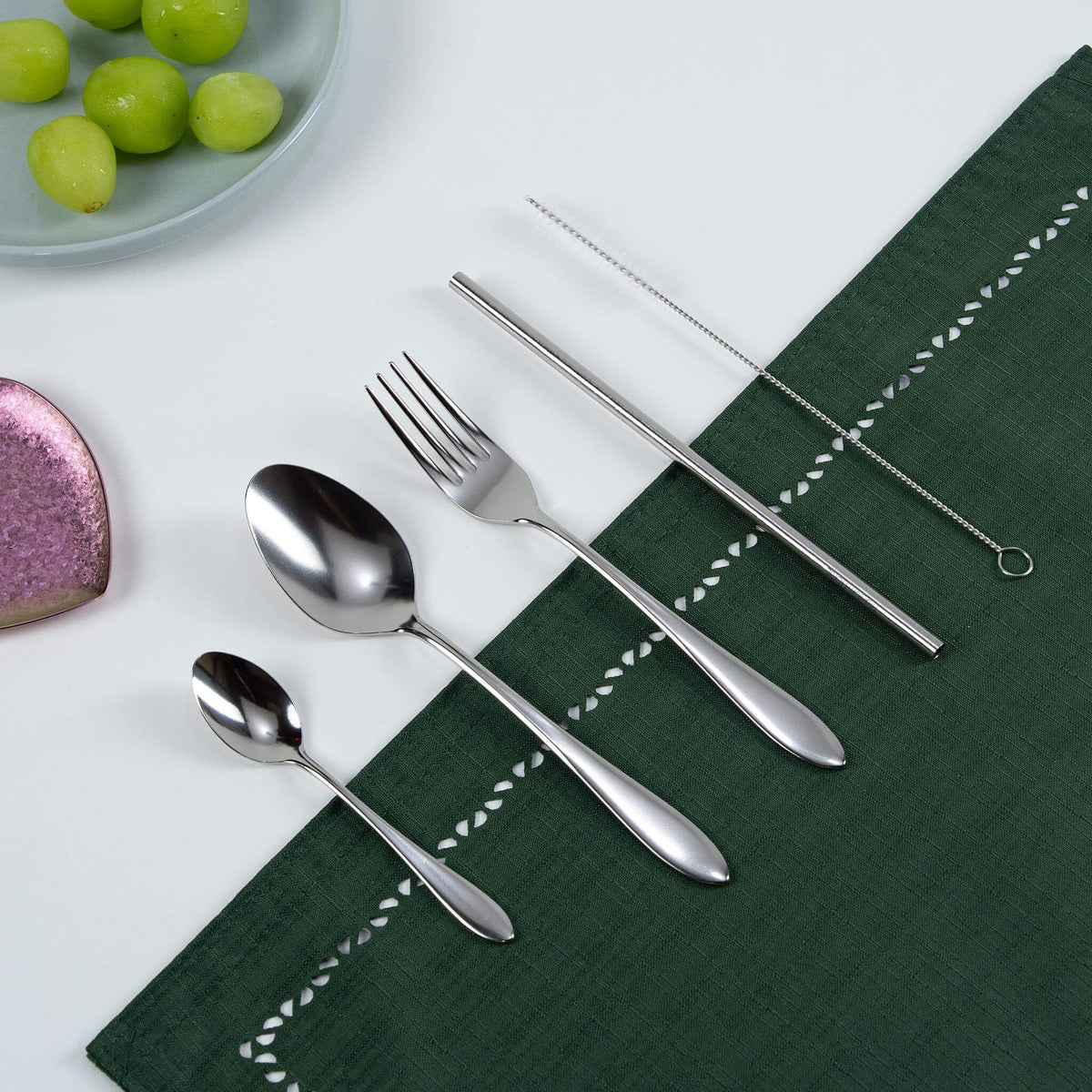 HORIE natural silver titanium cutlery set arranged on a green tablecloth