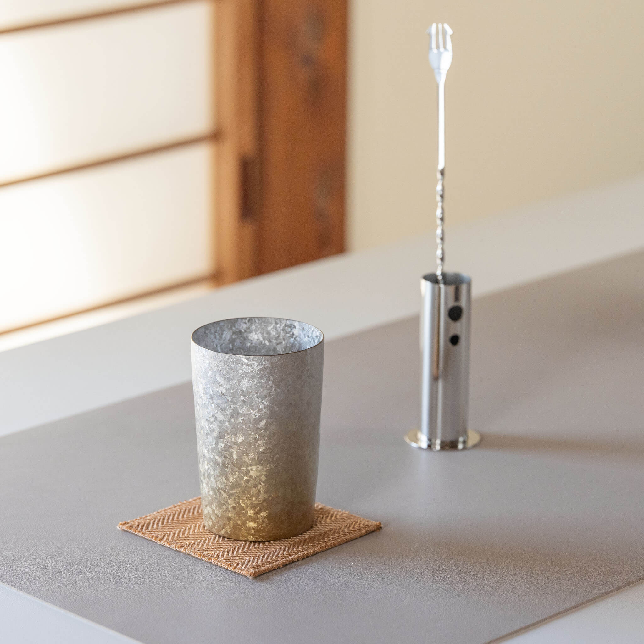 HORIE Titanium Kamazukuri 270ml Gold Silver Tumbler on coaster with bar spoon, warm lighting