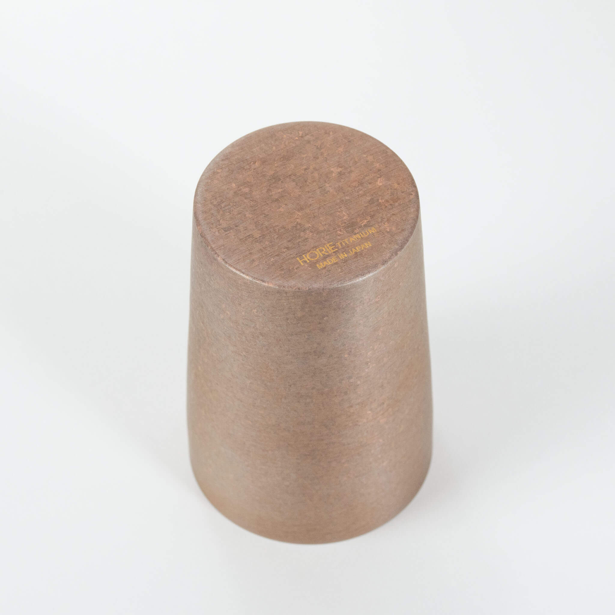 The bottom of the tumbler showing the authentic gold engraved logo text reading Titanium Horie Made in Japan.