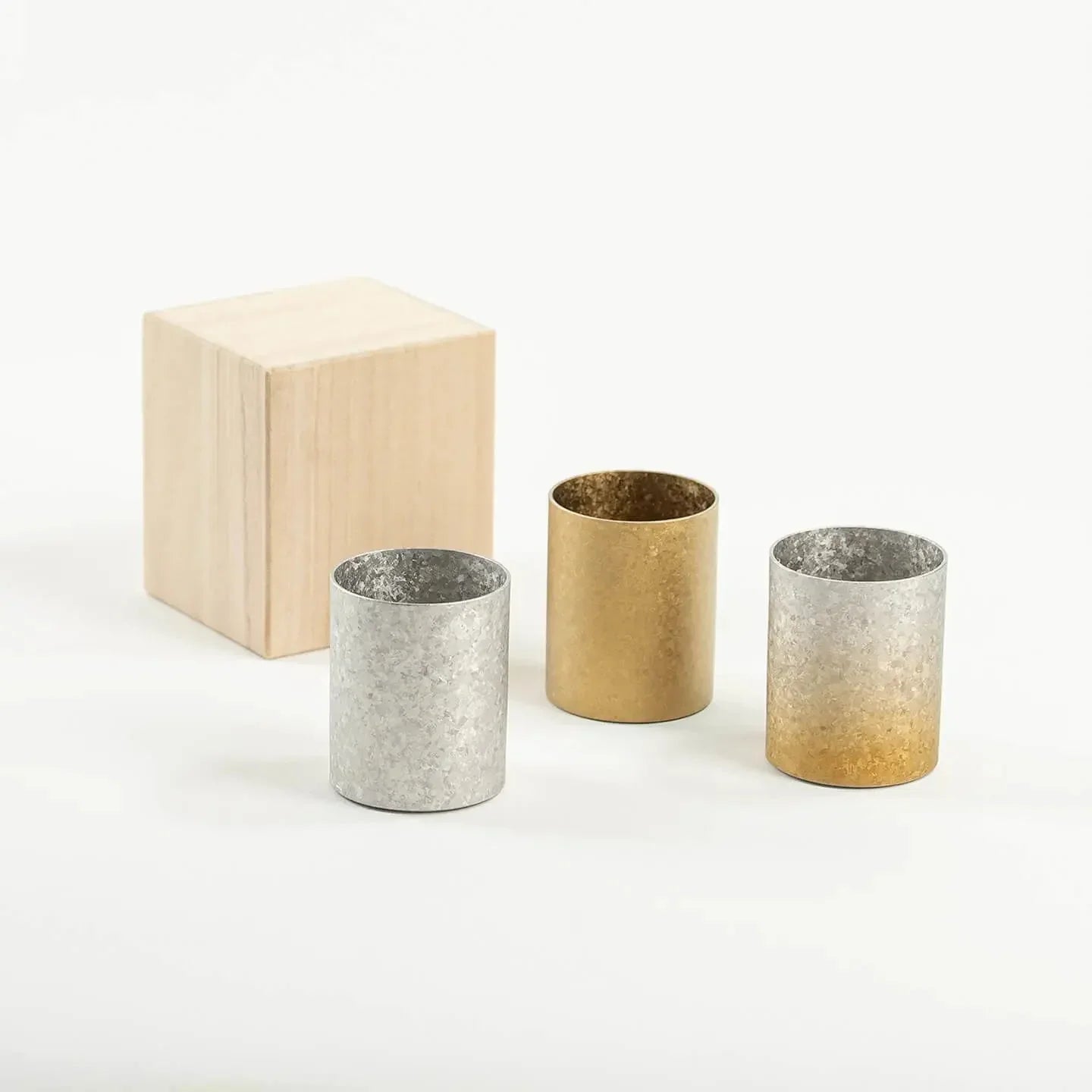 The HORIE Titanium Sake Cup shown in all three available finishes: Silver, Gold, and Gold & Silver Gradient.