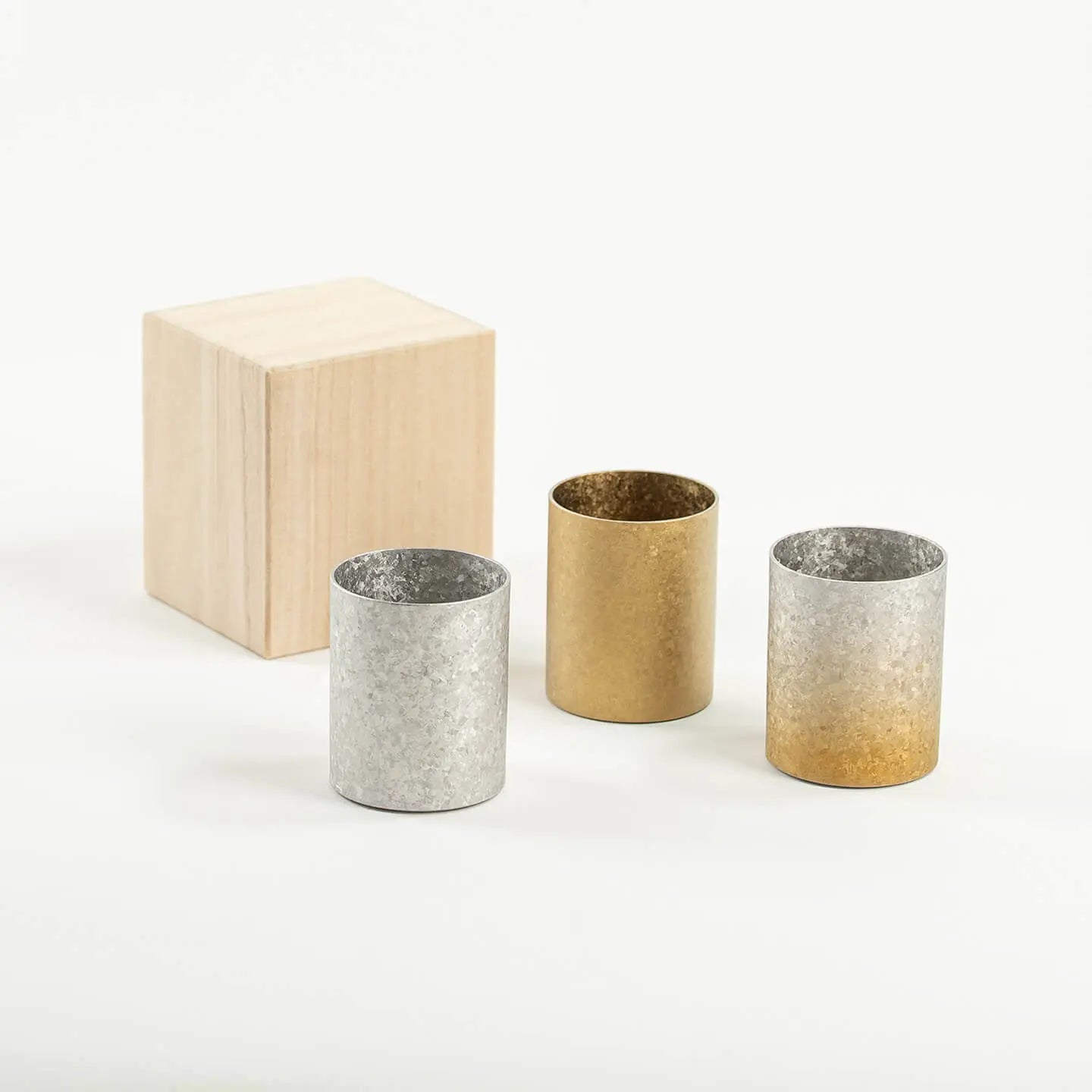 The HORIE Titanium Sake Cup shown in all three available finishes: Silver, Gold, and Gold & Silver Gradient.