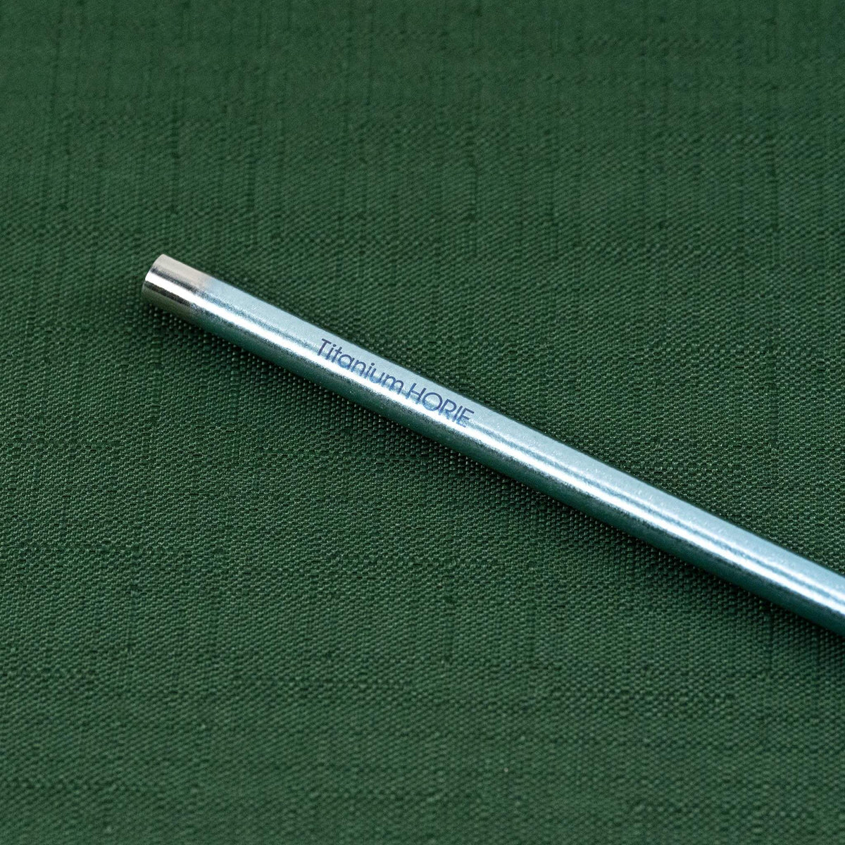 Close-up of the Titanium HORIE logo on the blue titanium straw