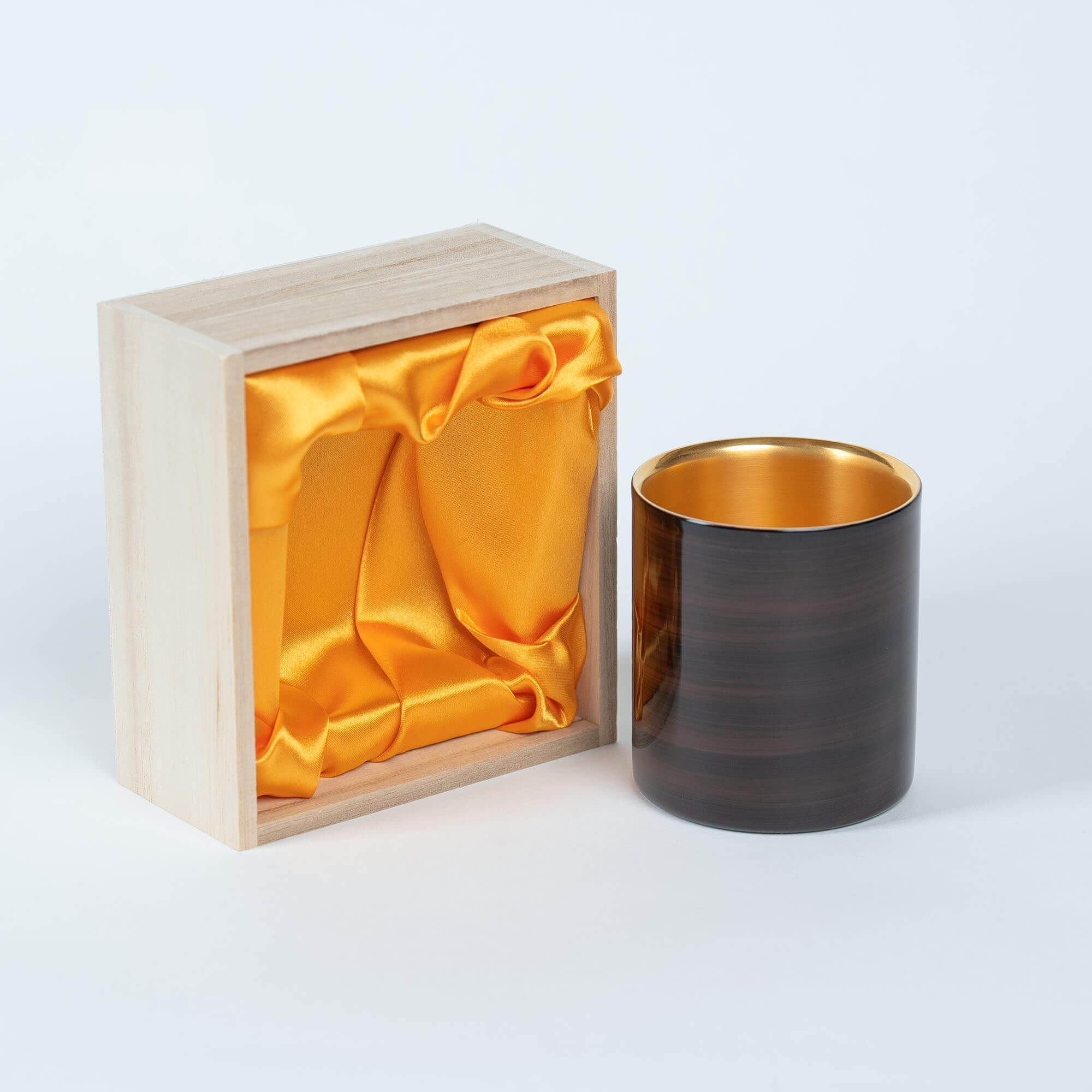 Brown Japanese lacquered 250ml sake cup with gold interior beside its wooden gift box