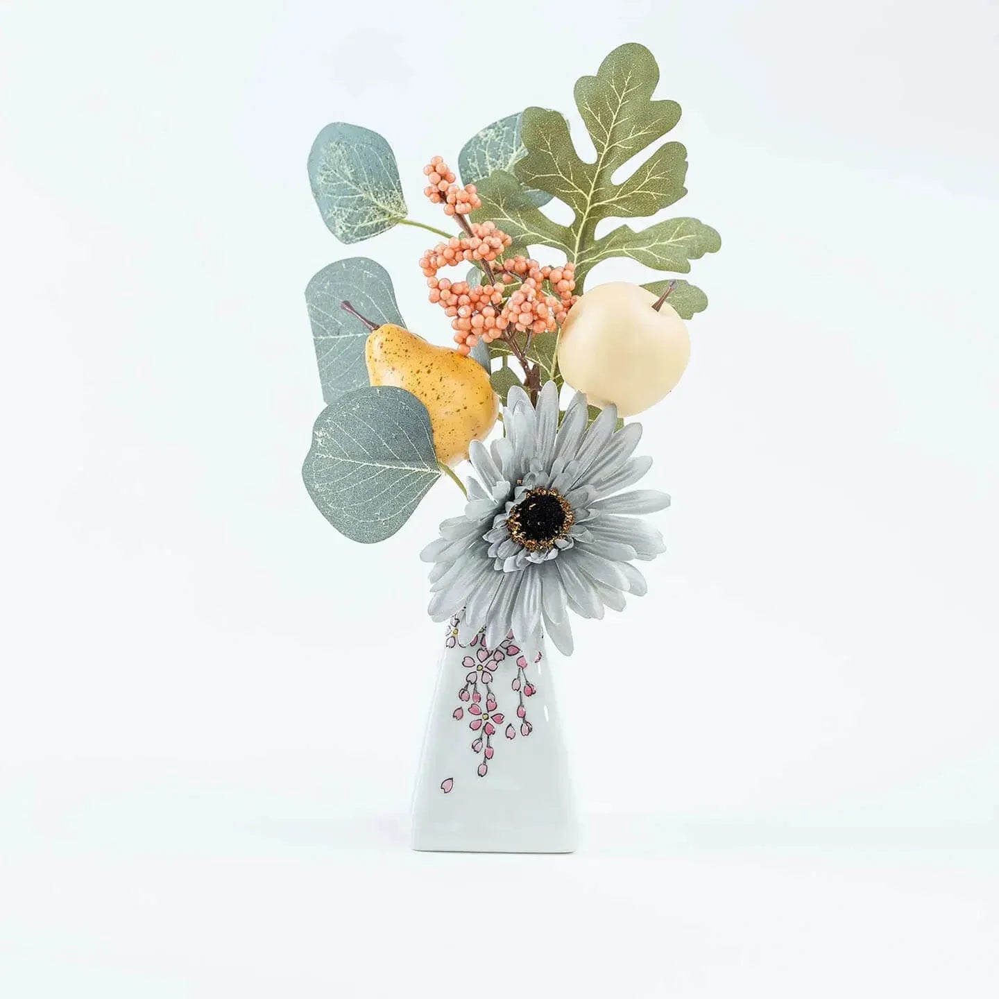 A white Kutani-yaki ceramic vase in the shape of Mt. Fuji with a pink cherry blossom pattern.