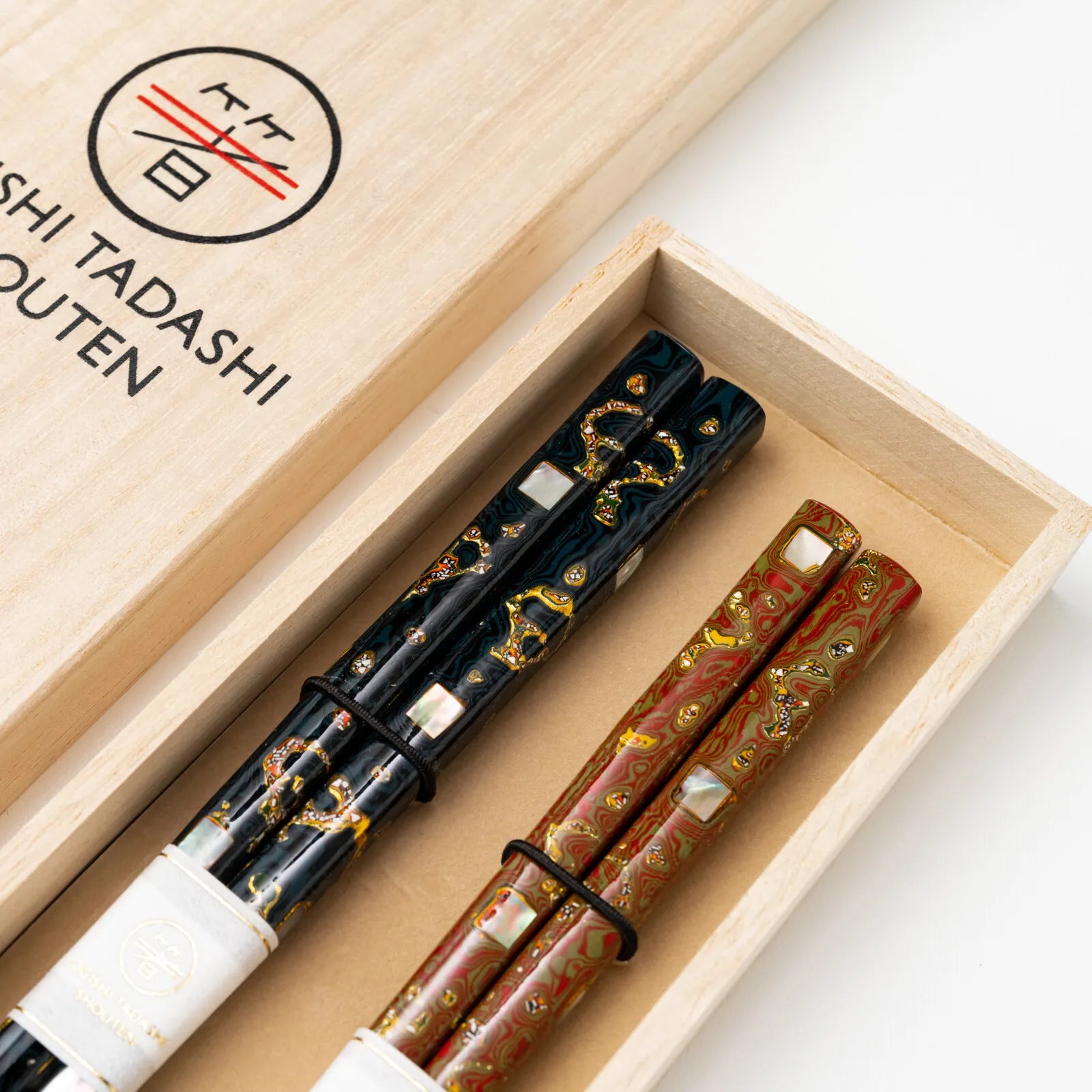 Close-up of shimmering abalone shell inlay on luxurious Japanese chopsticks.