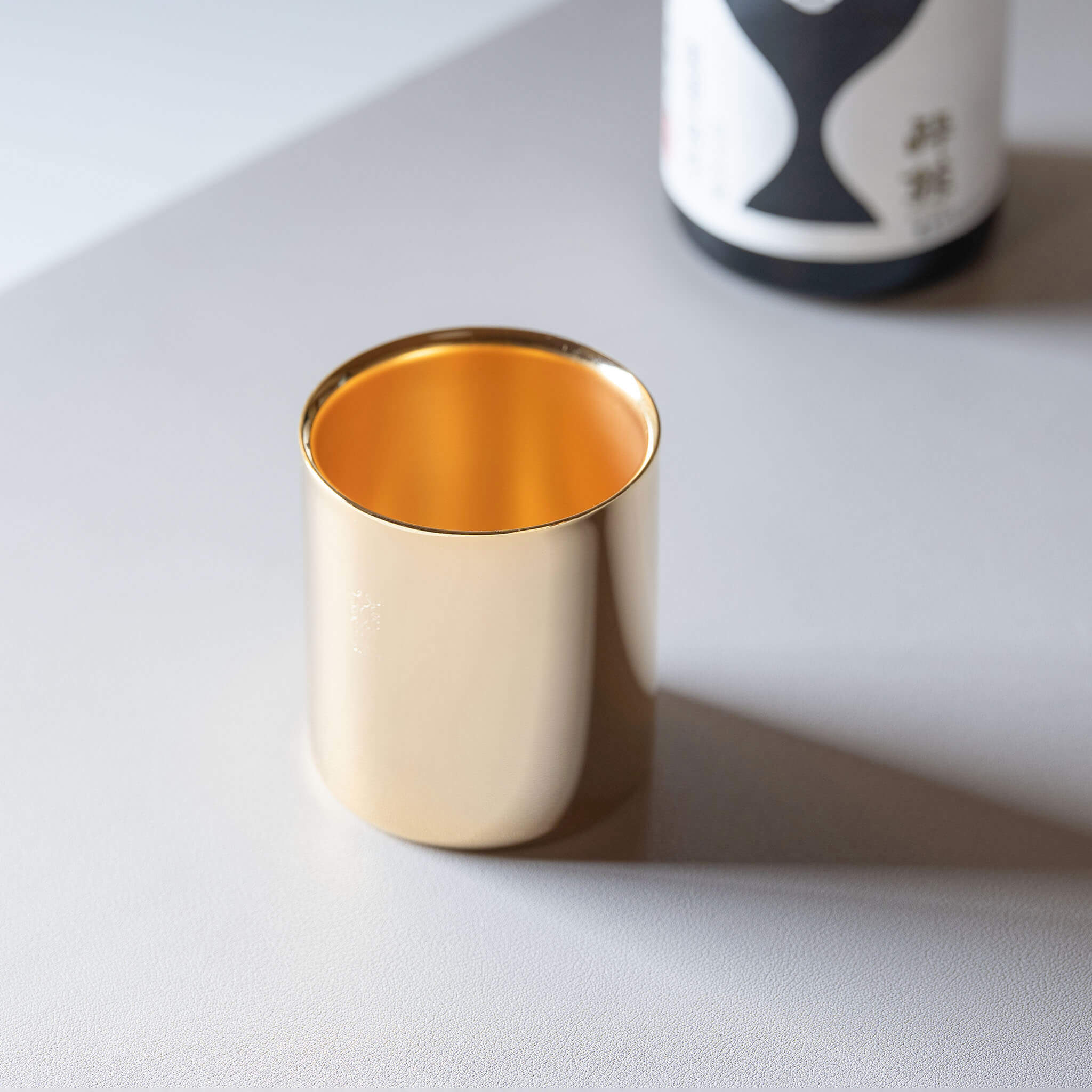 Luxury 24K gold-plated metal cup made in Japan, displayed in a premium lifestyle setting perfect for coffee or spirits.