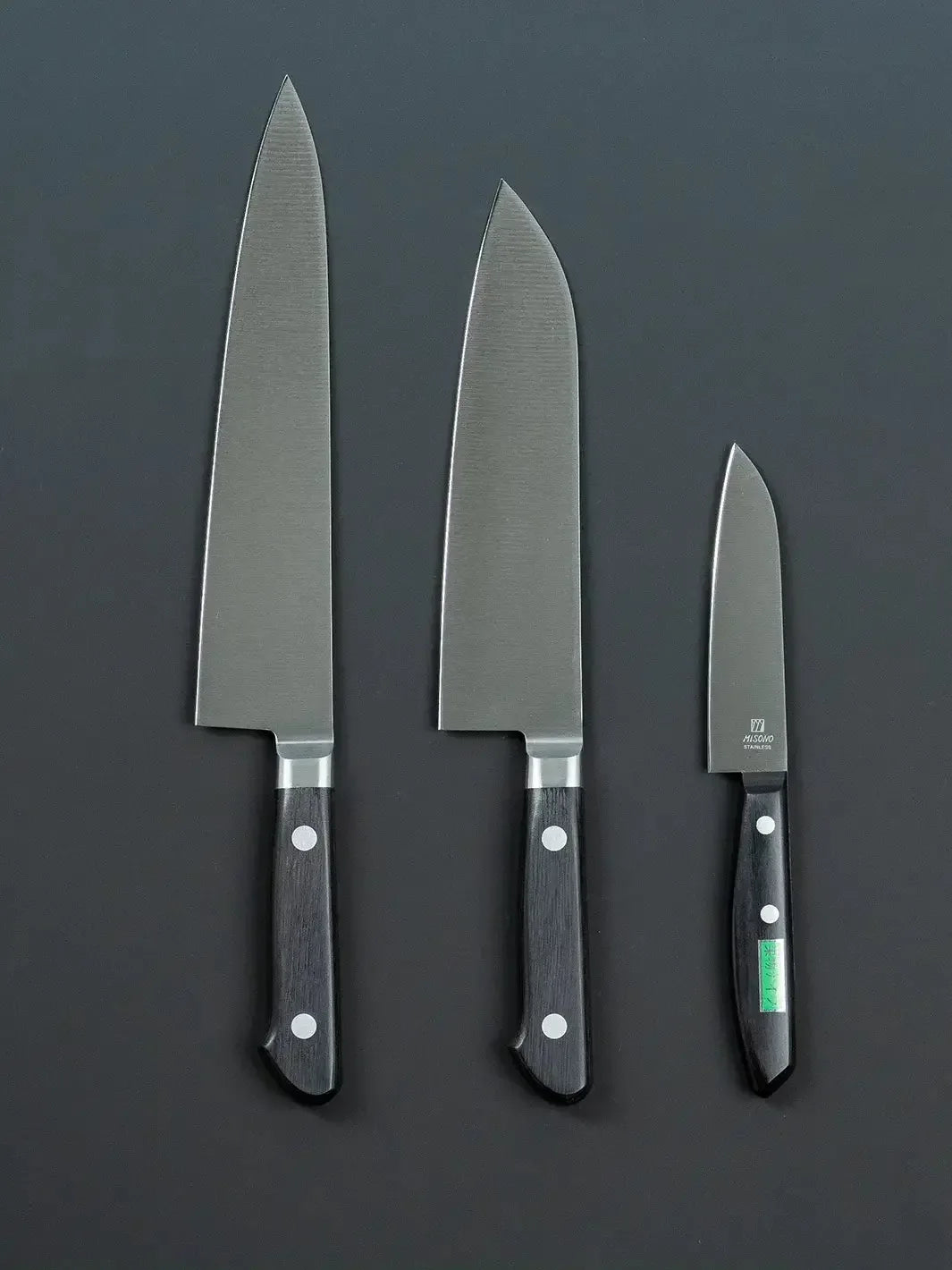 Back view of the Misono gyuto, santoku, and petty knives, showing the handle design and any back-side details.