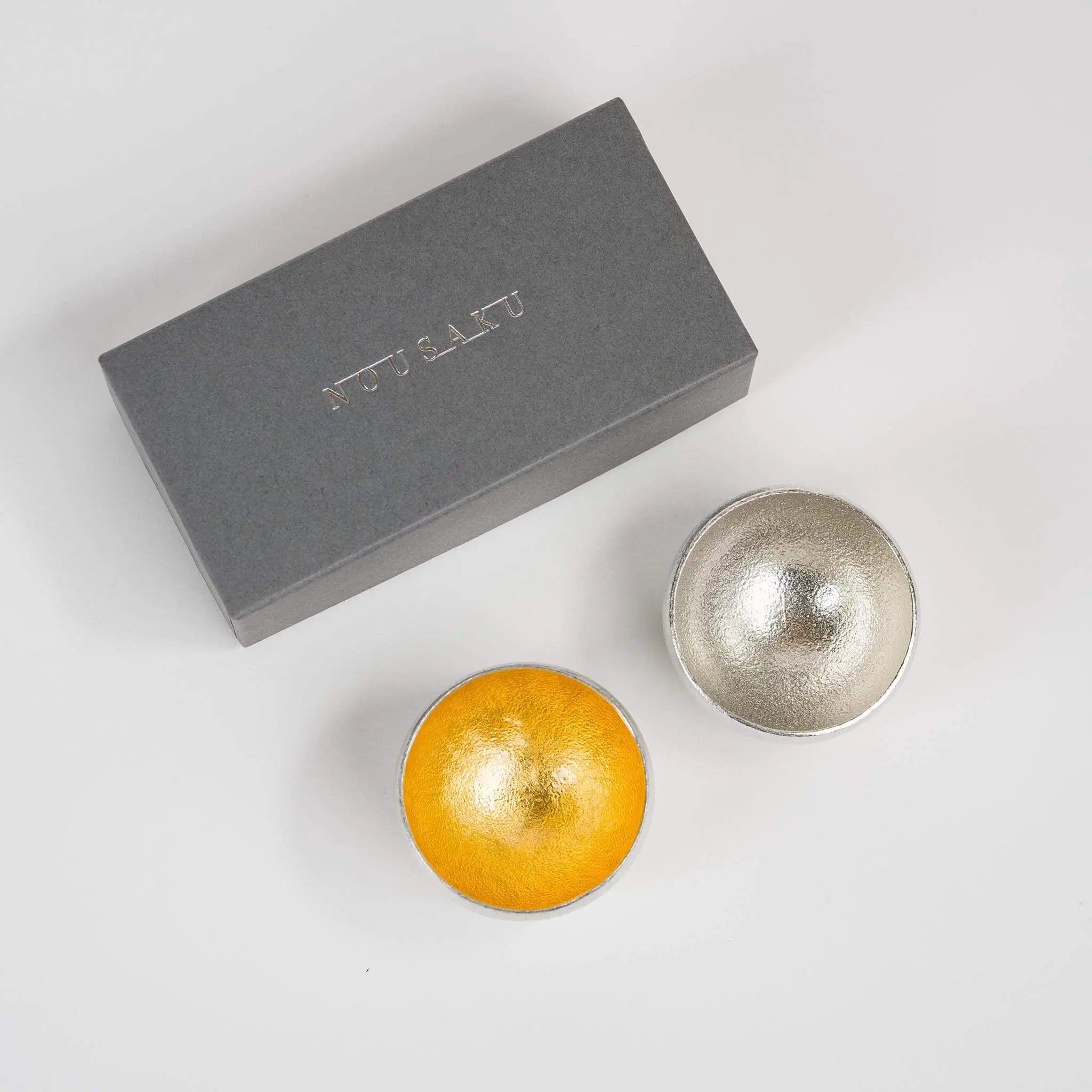 Aerial view of the gold leaf and pure tin rocking cups removed from their packaging.