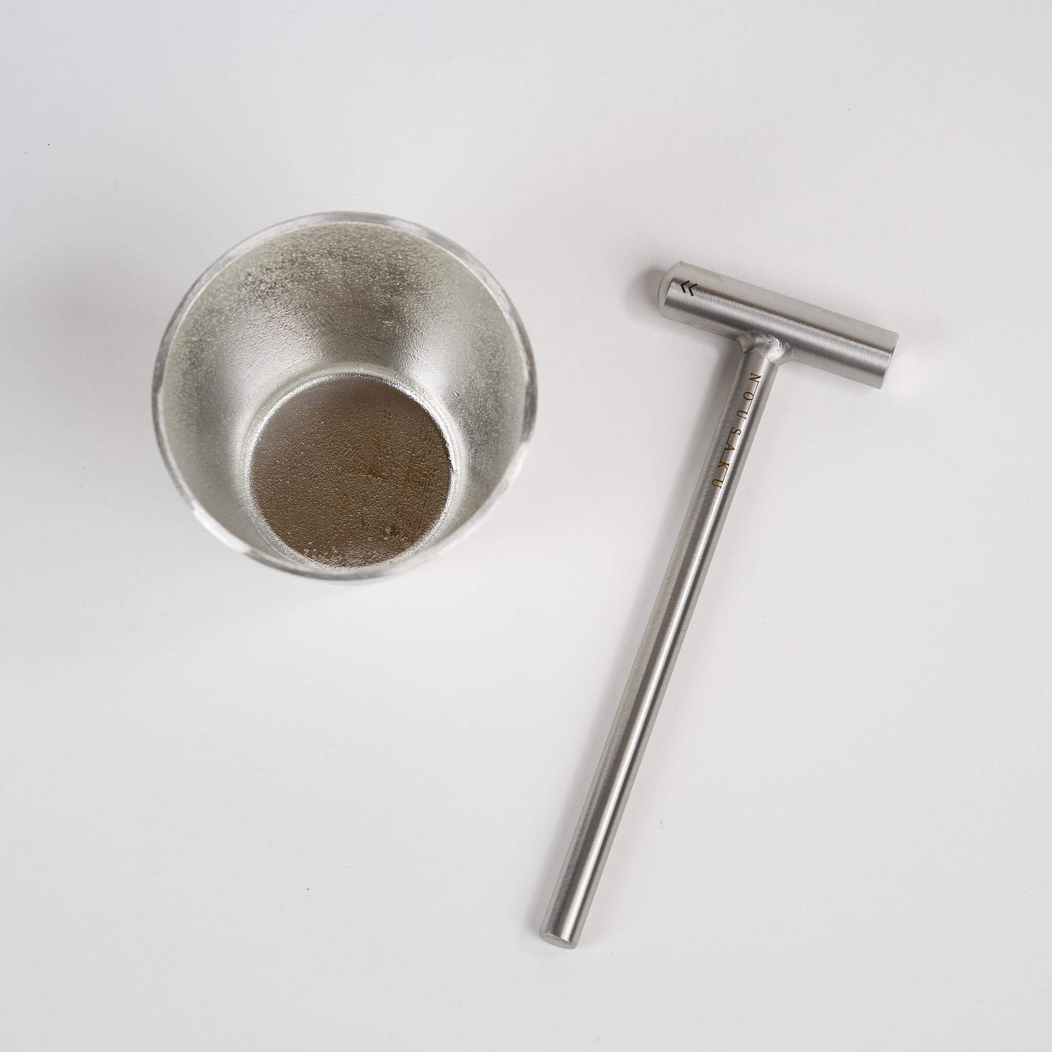 Nousaku pure tin cup paired with a specialized metalworking hammer for DIY crafting.