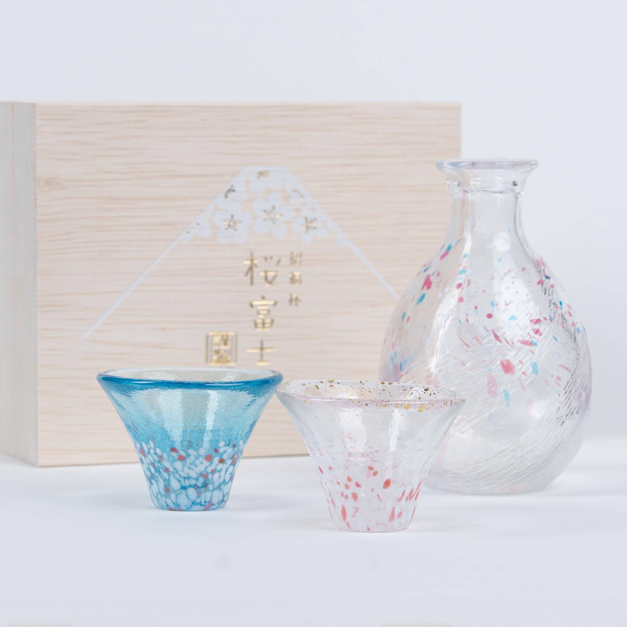 Close-up of handmade Japanese sake cups with sakura and Mount Fuji design, presented as a premium gift set.
