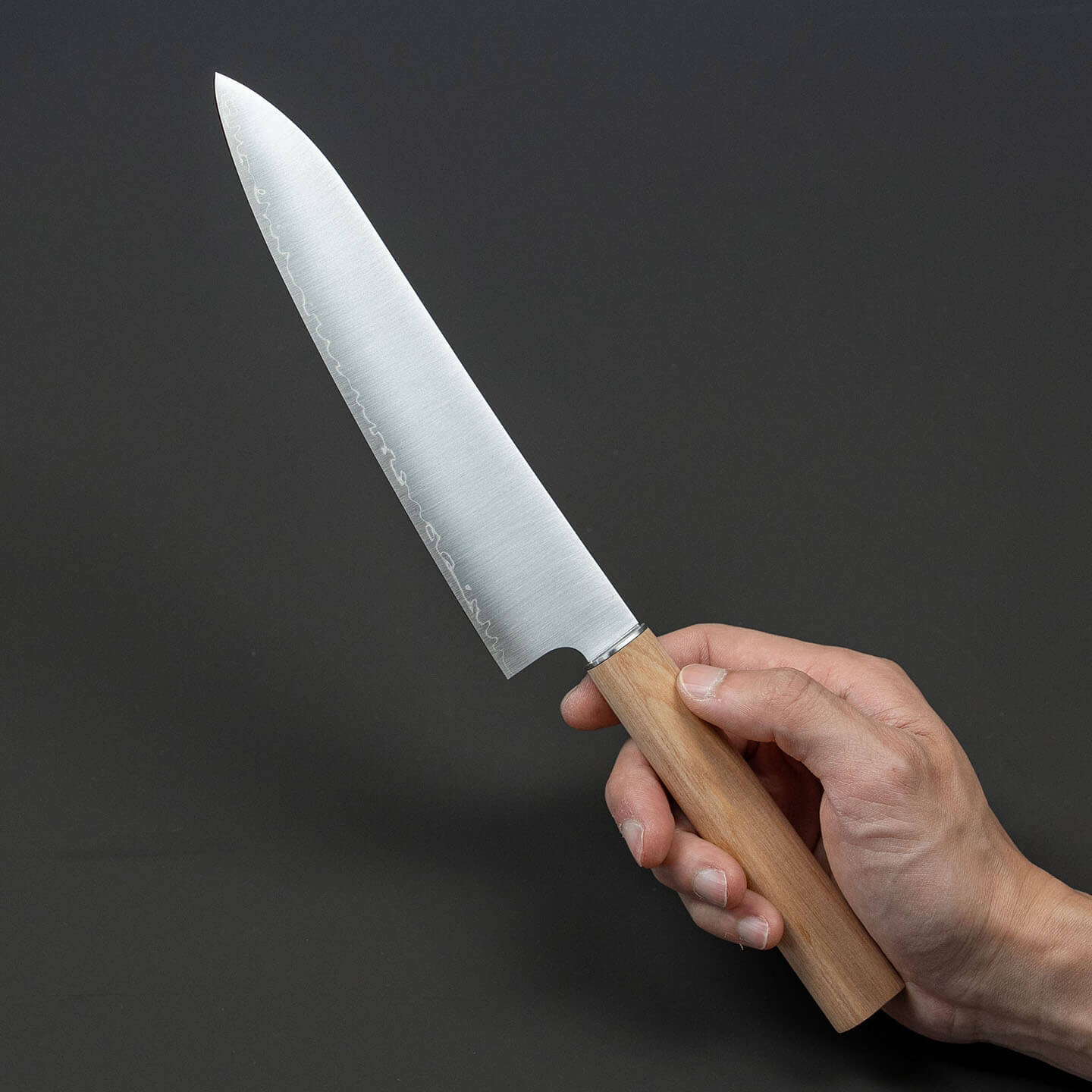 Hand holding a Shizu Hamono 190mm three-layer high-carbon steel chef knife