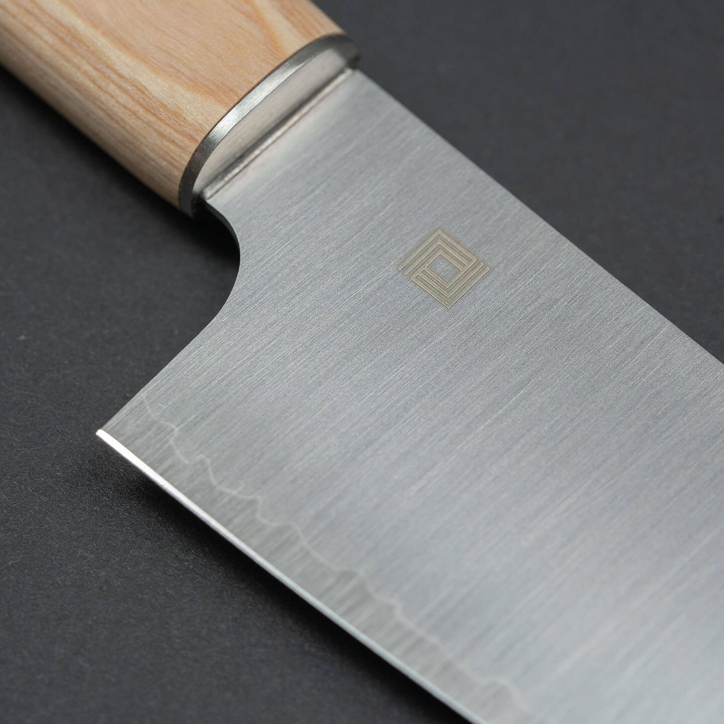 Close-up of the Shizu Hamono logo on the three-layer steel knife blade