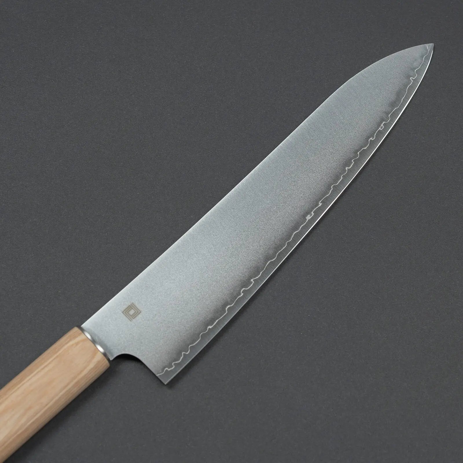 Close-up of 3-layer high-carbon steel blade with engraved logo