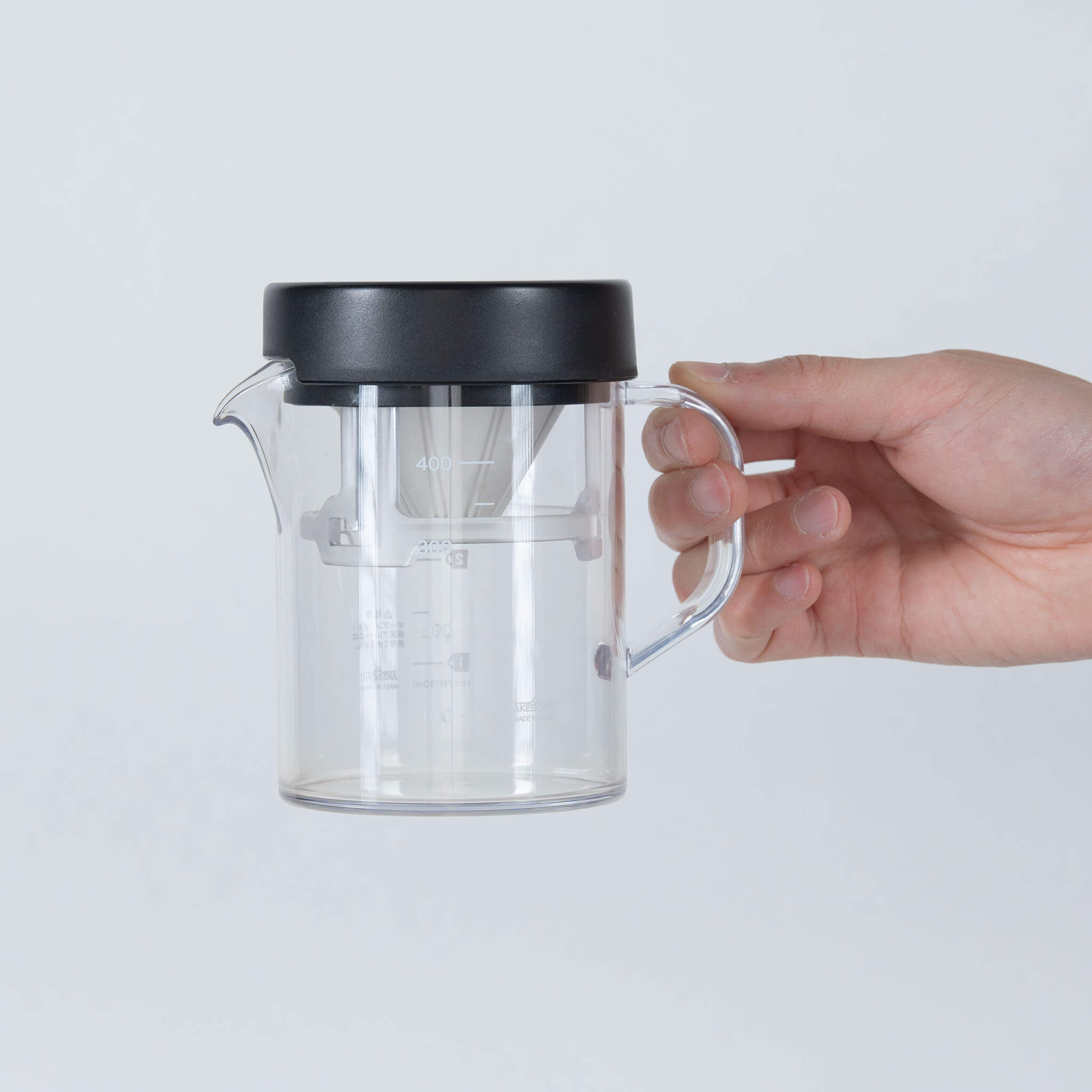 Hand holding STRON Compact Dripper Set in compact storage mode, front view