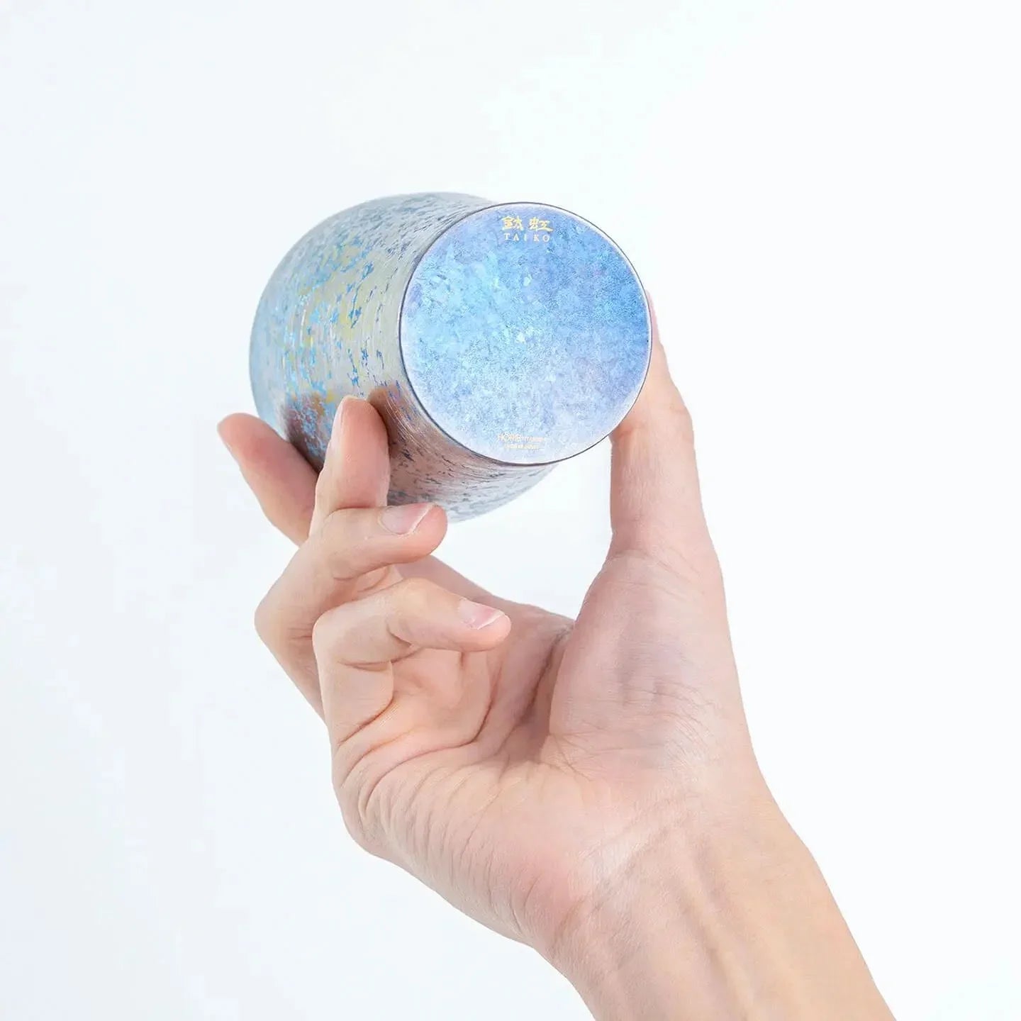 Bottom of blue titanium tumbler displayed in hand