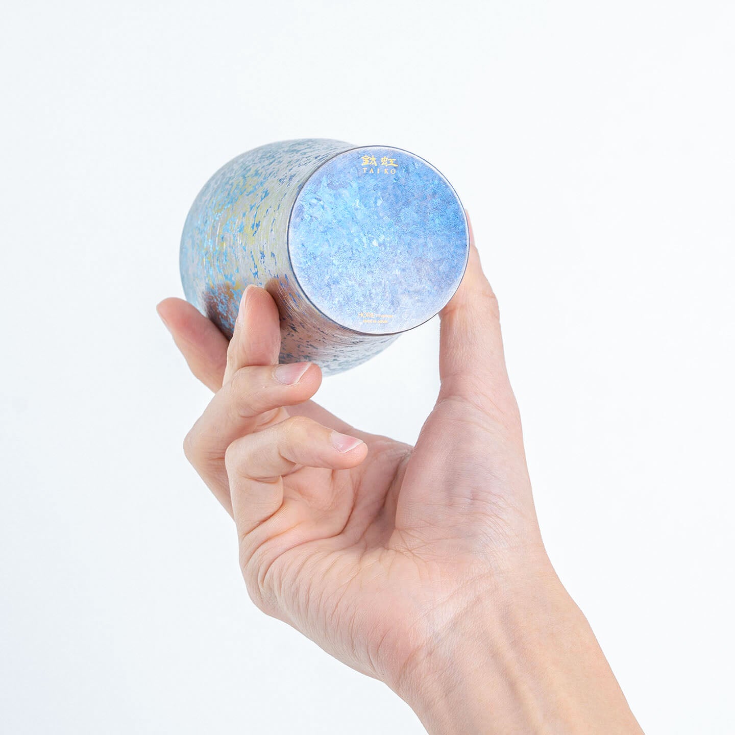 Bottom of blue titanium tumbler displayed in hand