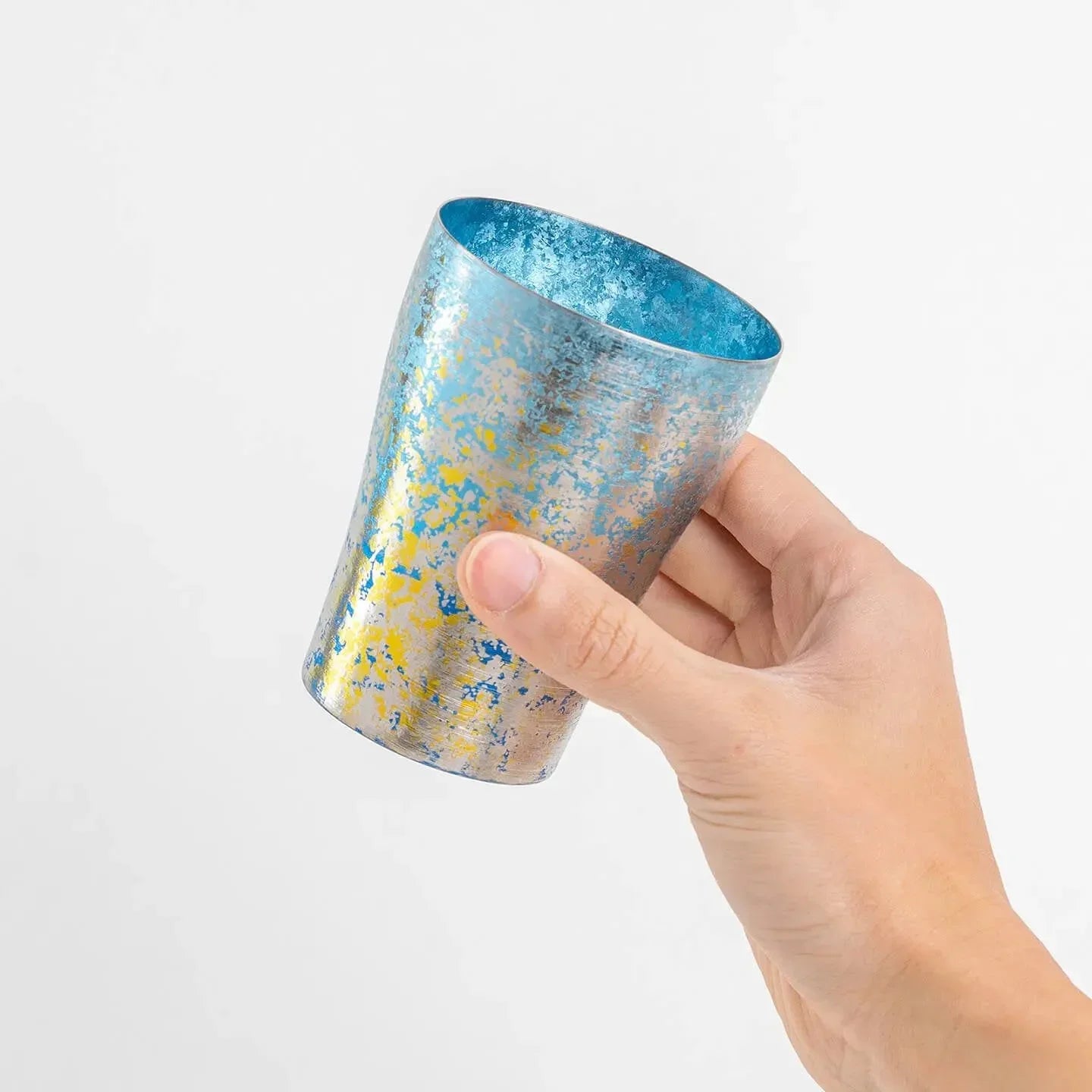 Hand holding blue HORIE tumbler
