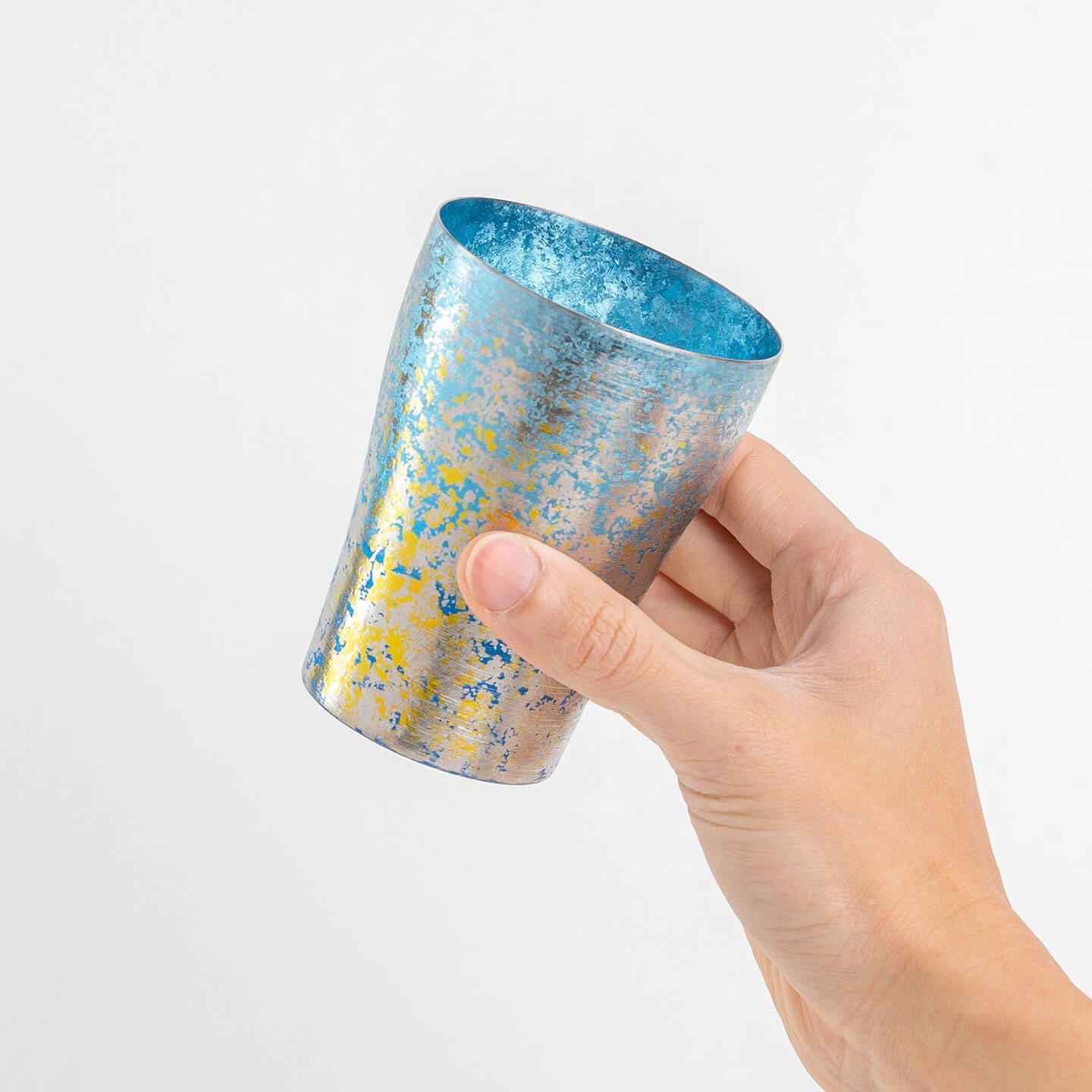 Hand holding blue HORIE tumbler