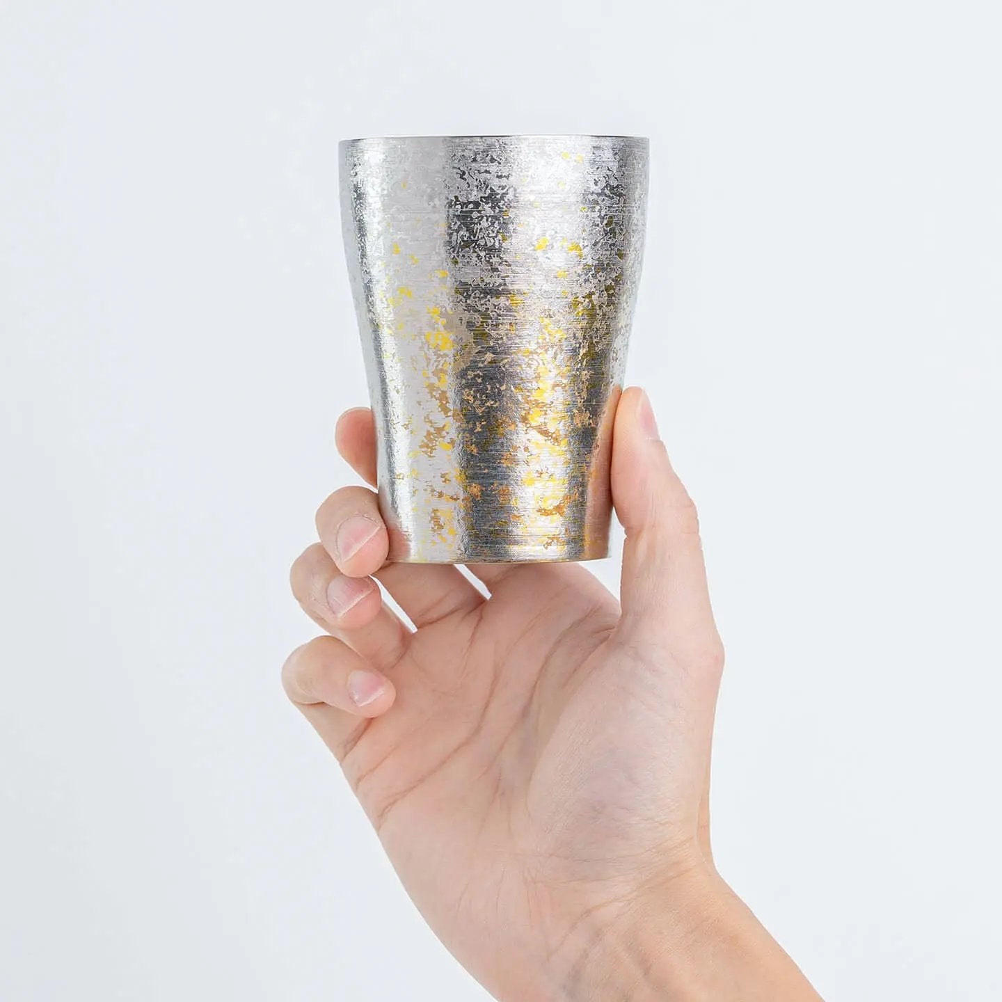 Hand holding the Taiko Series Silver Titanium Tumbler for size reference.